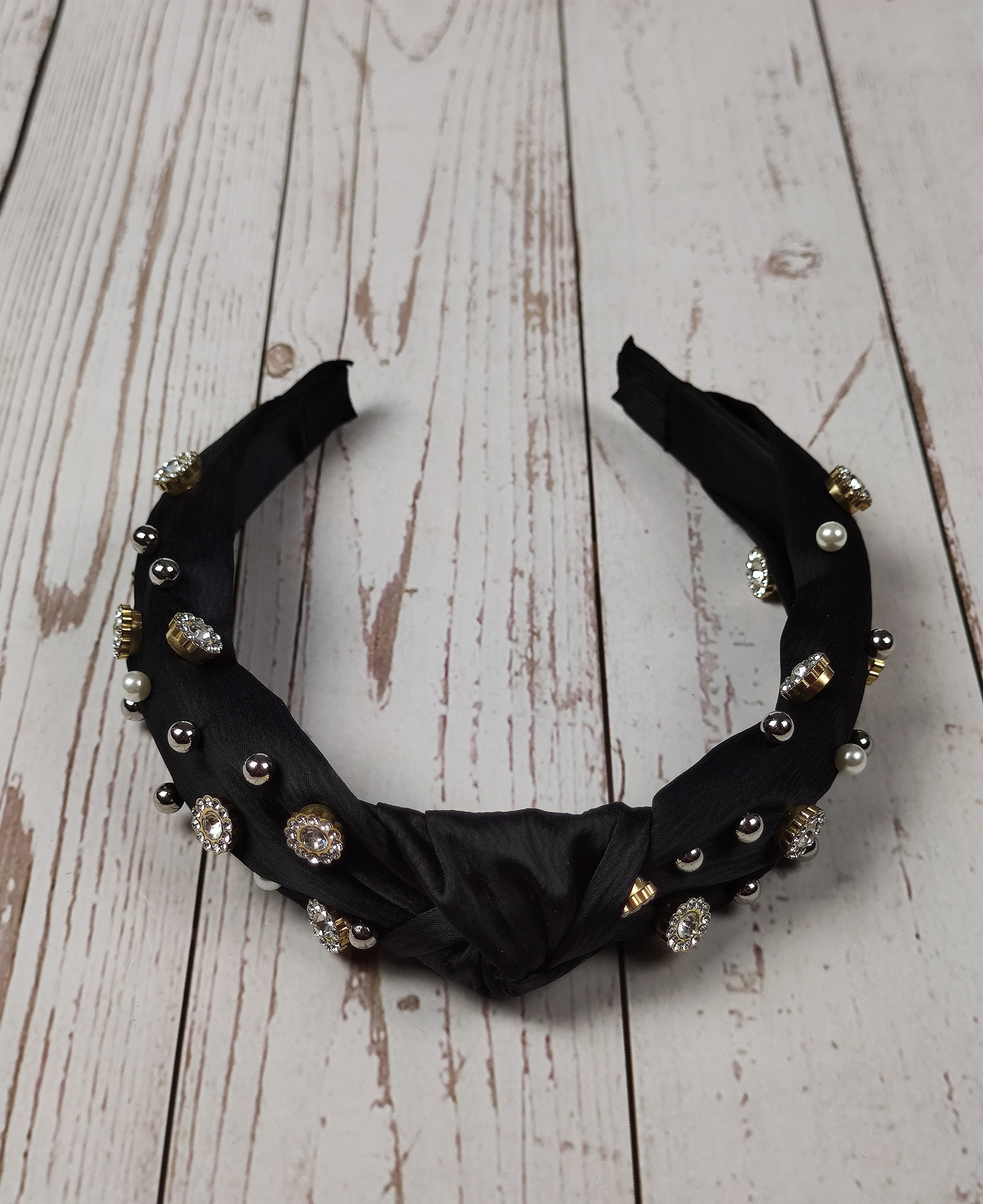 Treat her to a unique and stylish hair accessory with this black satin knotted headband, embellished with precious gems and pearls.