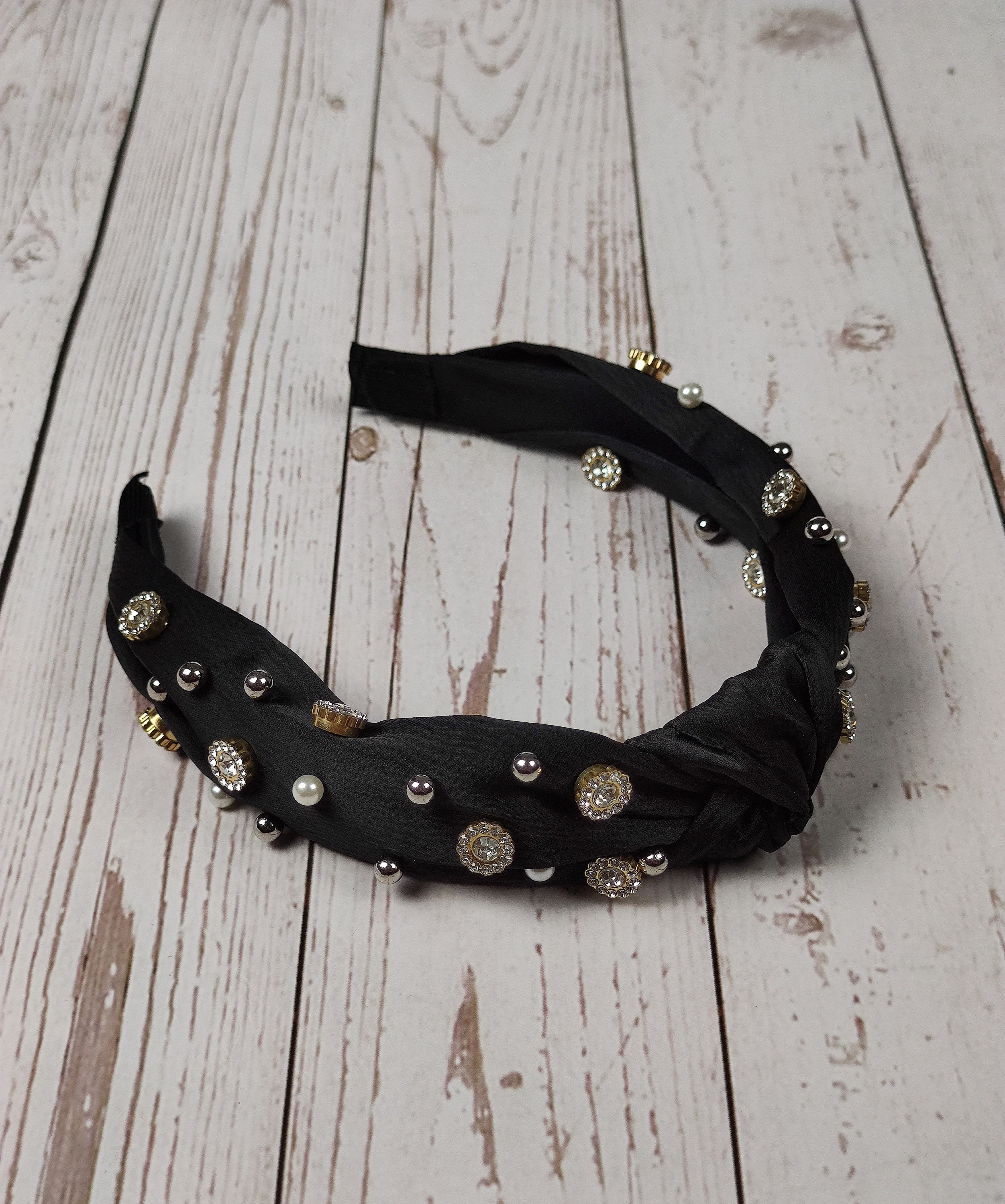 The ultimate hair accessory for fashion-forward women - a stylish black satin knotted headband with gemstones and pearls.