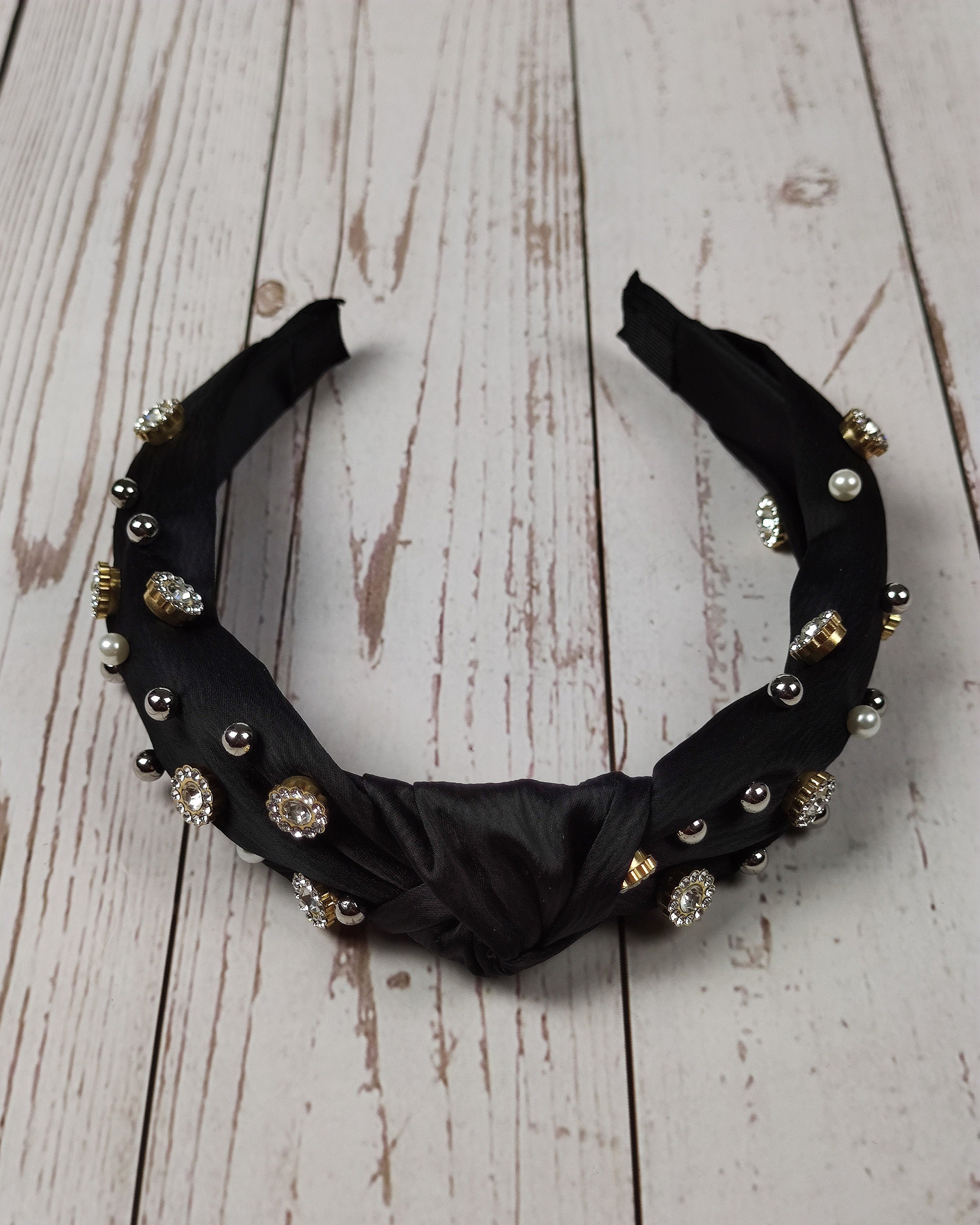 Elevate her hair game with this special black satin headband, featuring a sparkling gemstone and pearl embellishment.