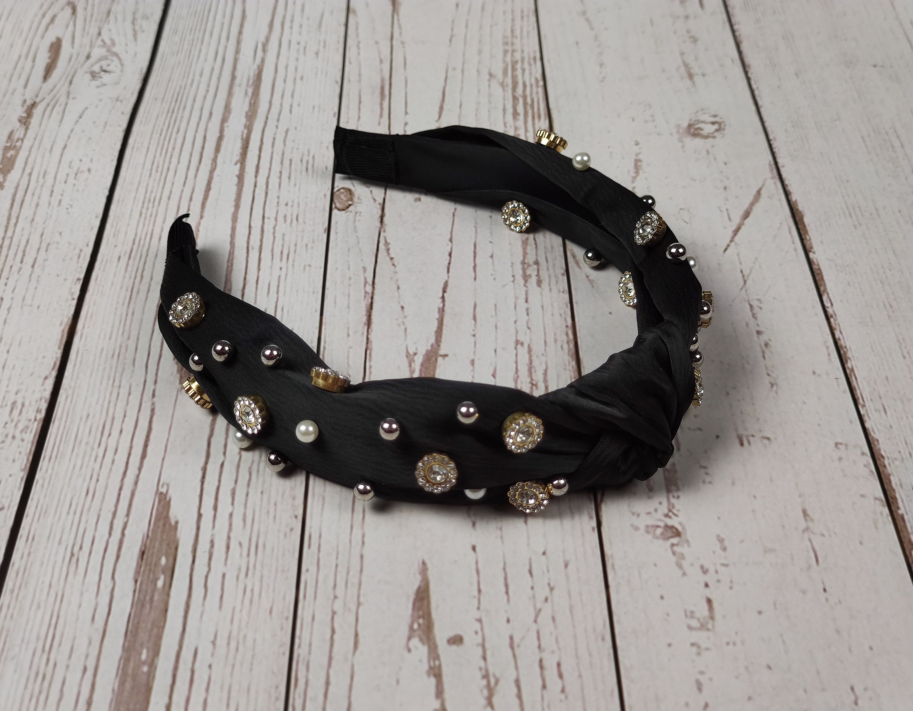 Stand out from the crowd with this special black satin knotted headband, designed with a chic boho touch and sparkling gemstones and pearls.