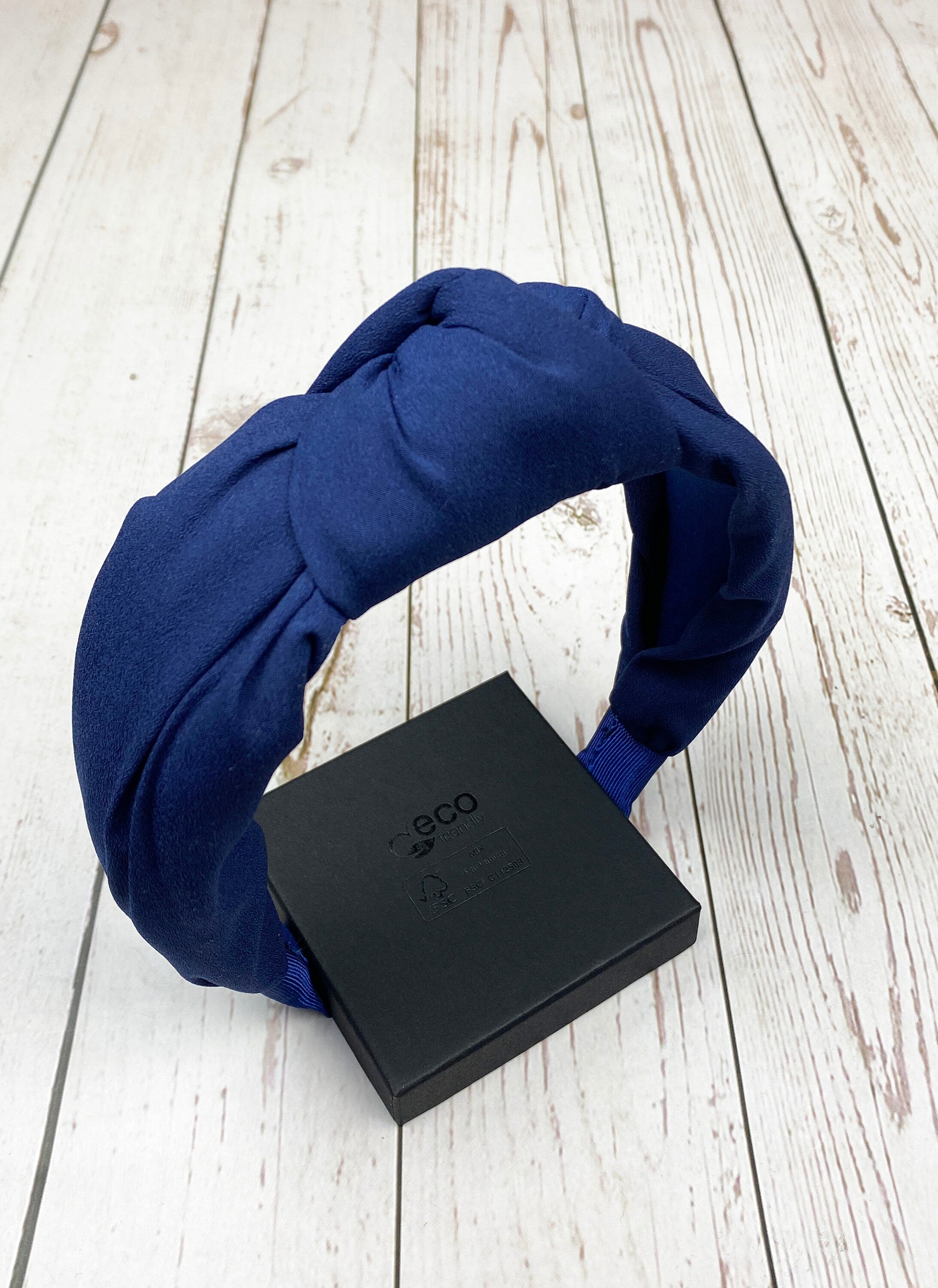 Stay comfortable and fashionable with this navy blue padded headband, perfect for any outfit.