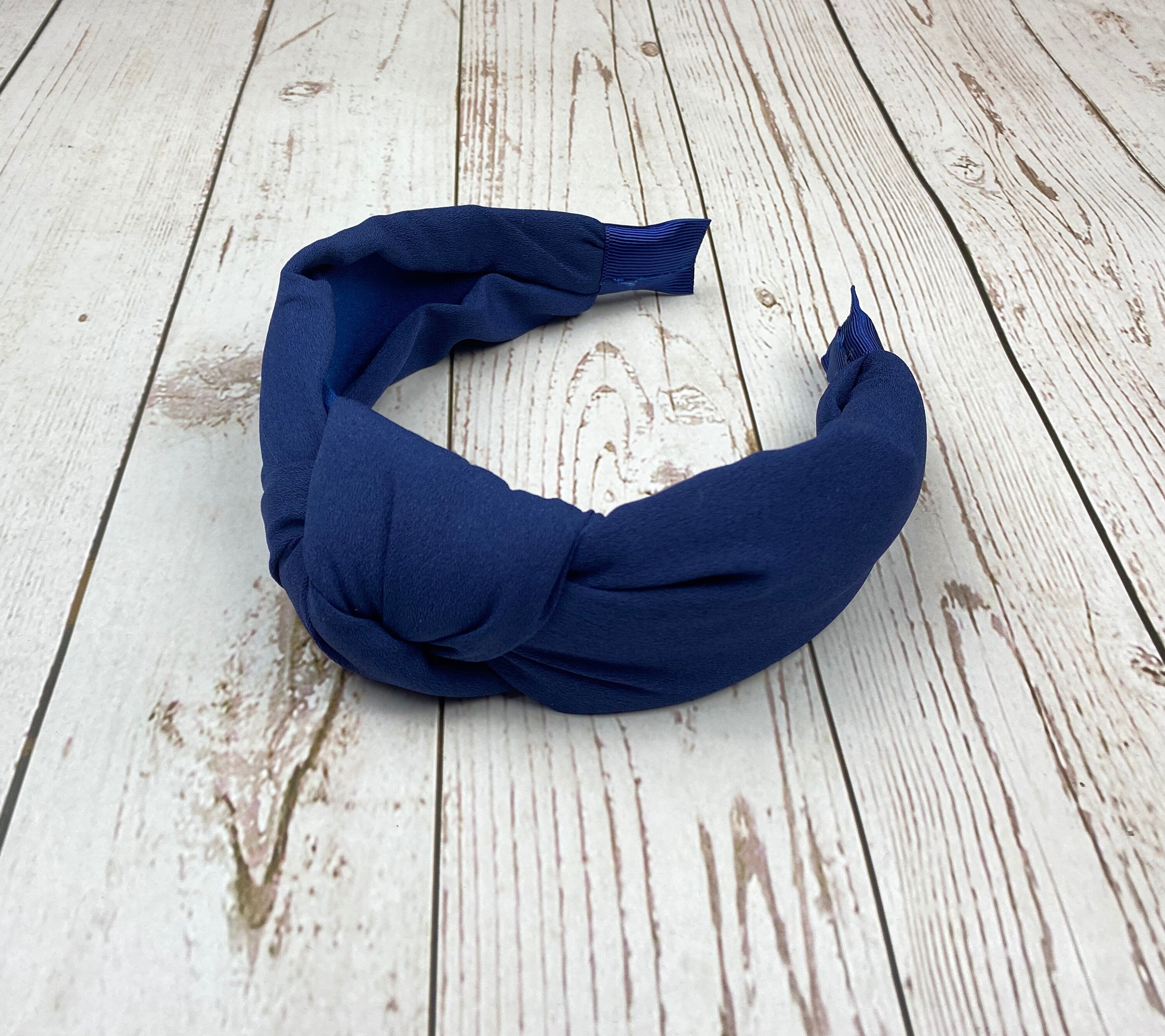Stay stylish and comfortable with this navy blue padded headband, a versatile accessory for any hair type.