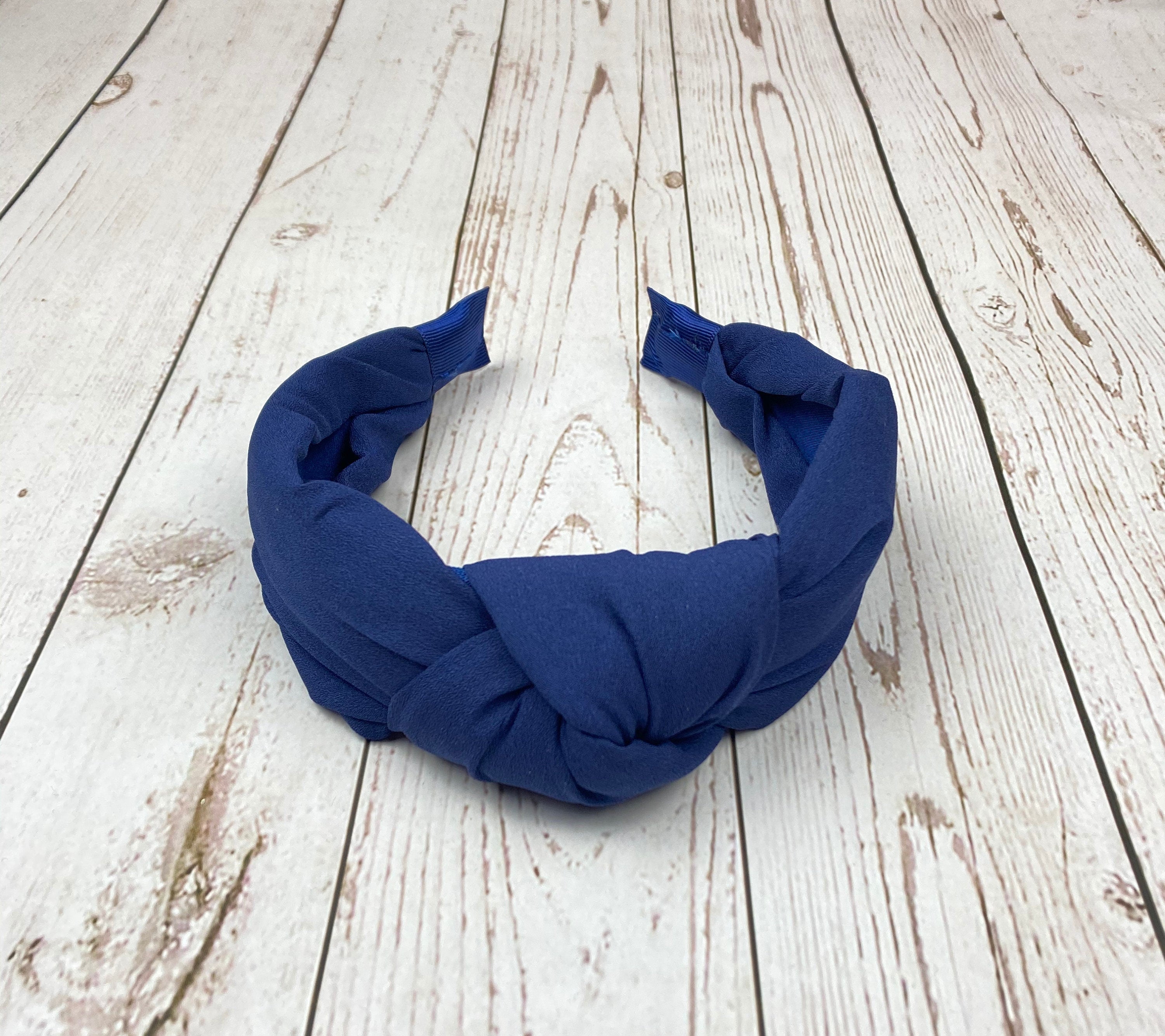Elevate your style with this navy blue twist headband, a chic and classic accessory for women.