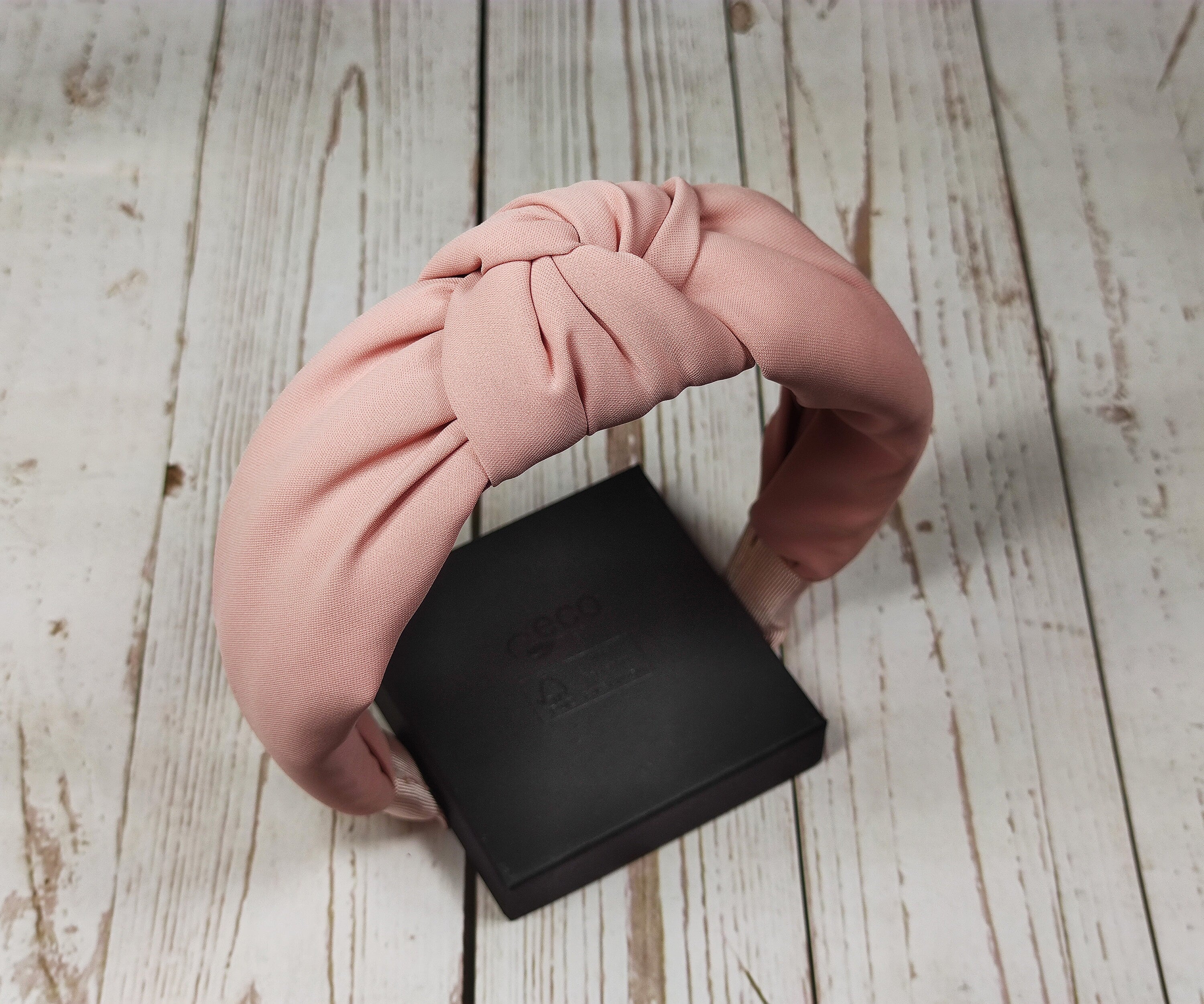 Take your style up a notch with Viscose Crepe Pinkish Orange Headband! Its colorful design will brighten up any outfit and its delicate fabric will make you feel confident and feminine all at the same time.