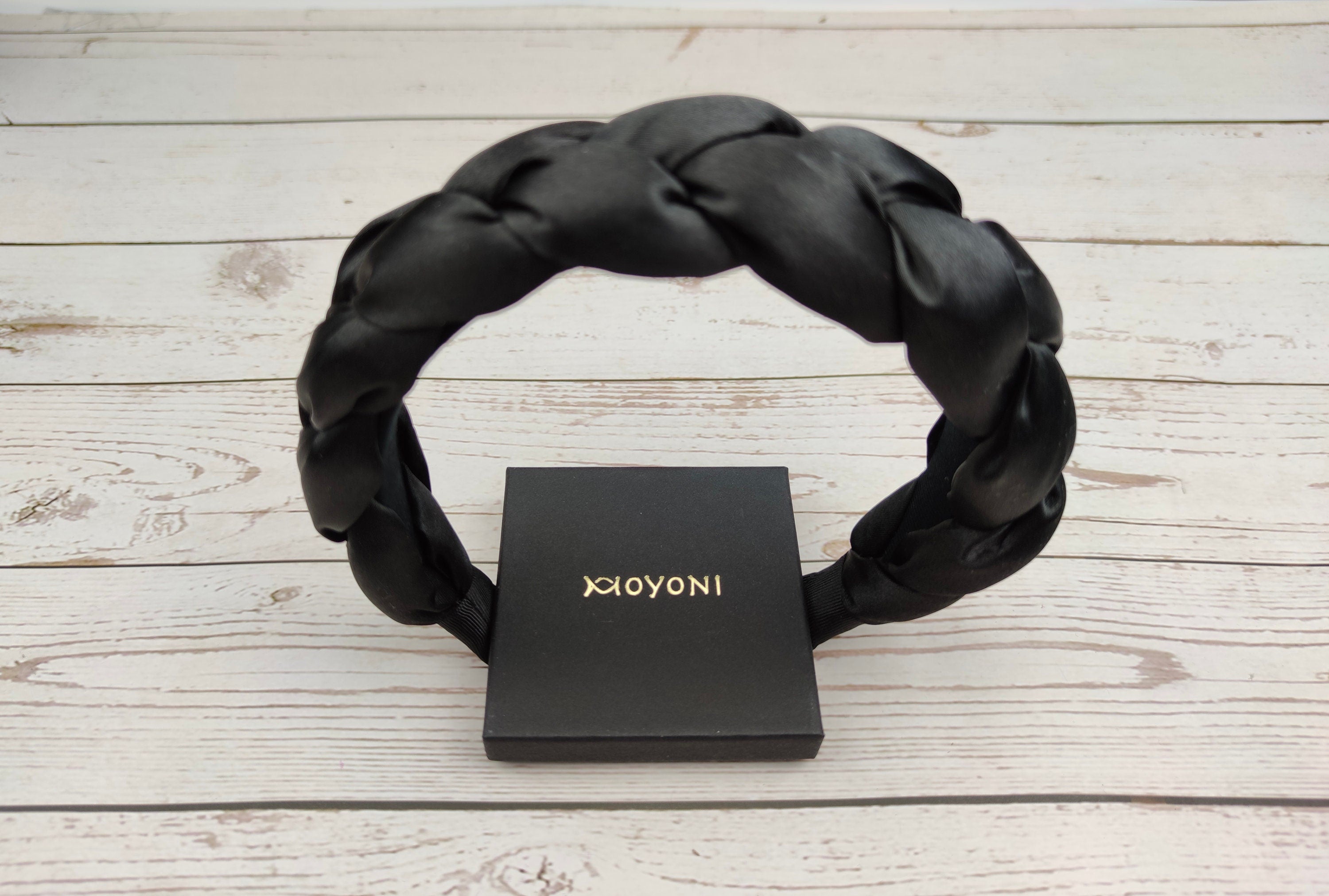 Get the perfect finishing touch for your little girl's outfit with this black headband, featuring a comfortable padded design.