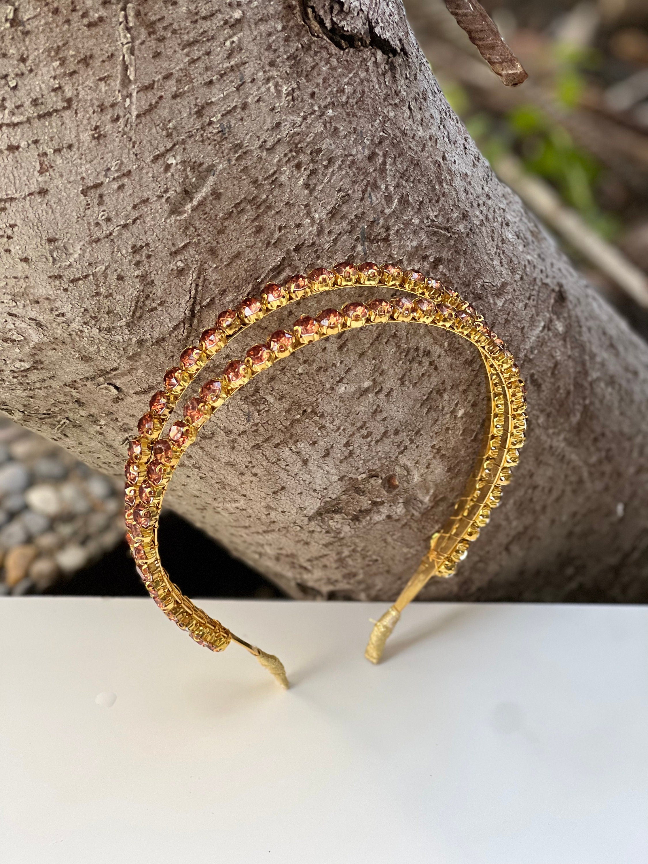 Looking for a chic and stylish wedding accessory? Look no further than this gold and brown crystal headband. With its shiny finish and stunning crystal accents, it's the perfect addition to any bridal ensemble.
