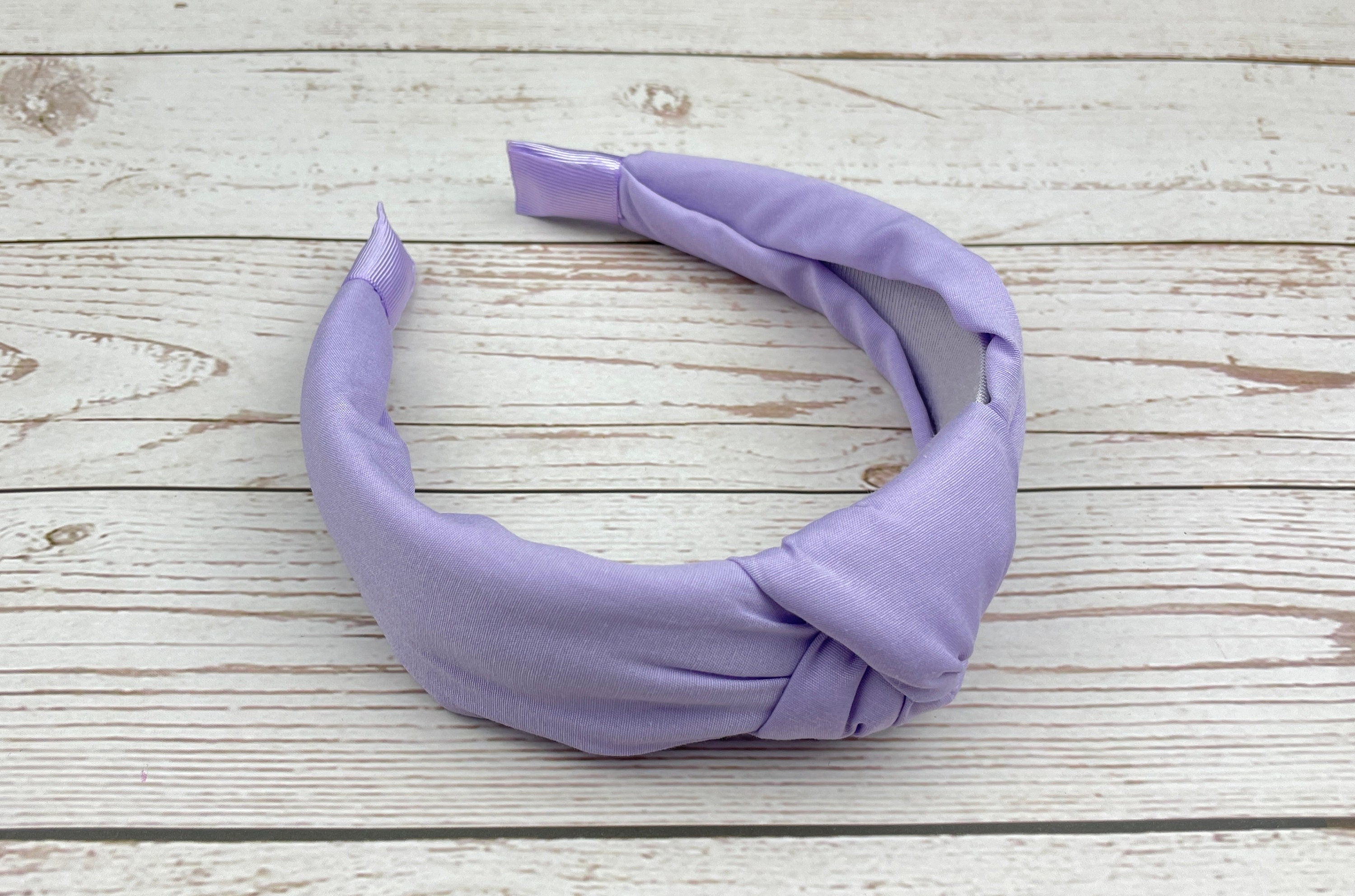 This light-colored elegant hairband is perfect for adding a touch of sophistication to any outfit.