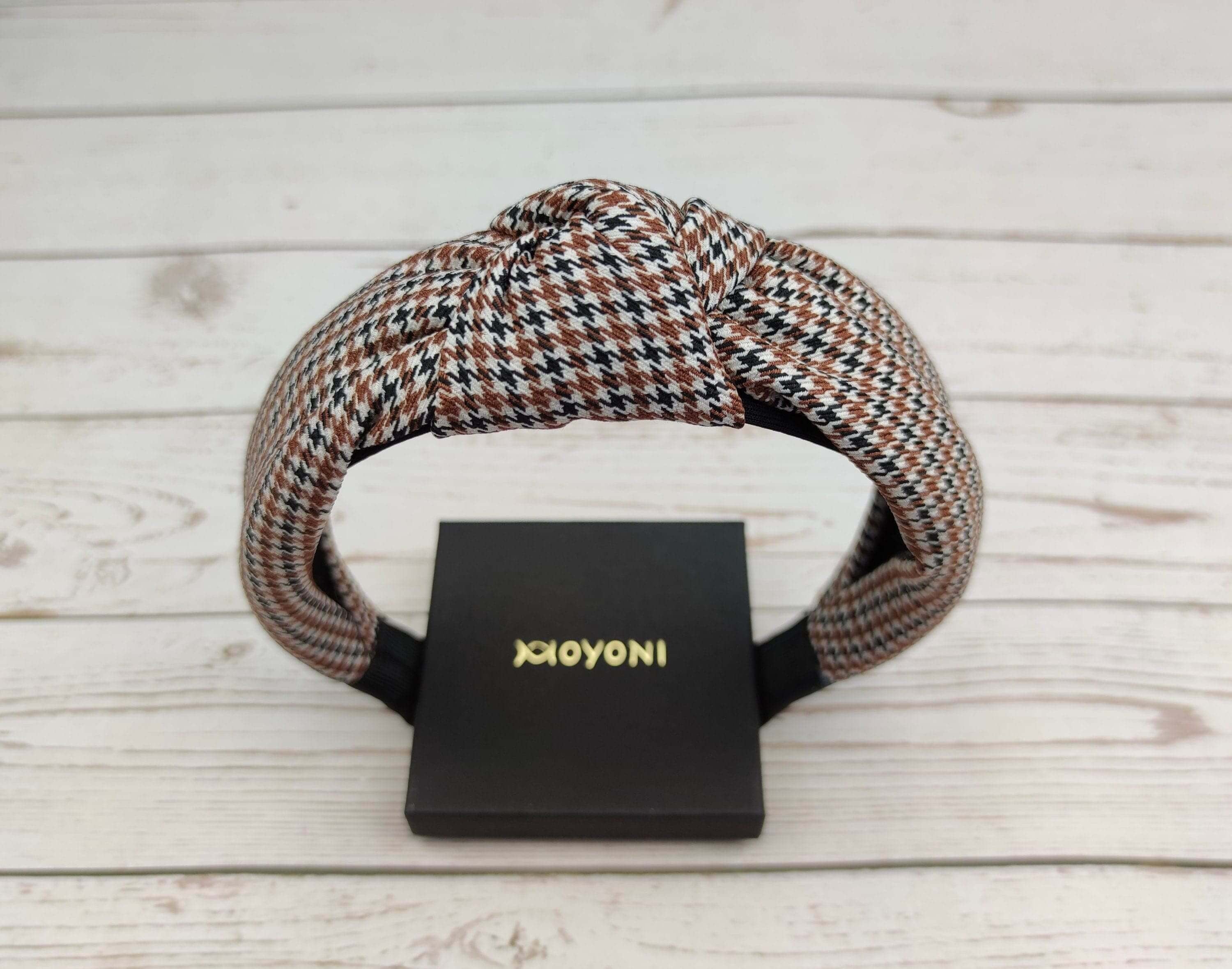 Elevate your everyday look with this beautiful crepe white, black, and brown knotted headband. Perfect for college and any occasion, it adds a touch of sophistication to any outfit.
