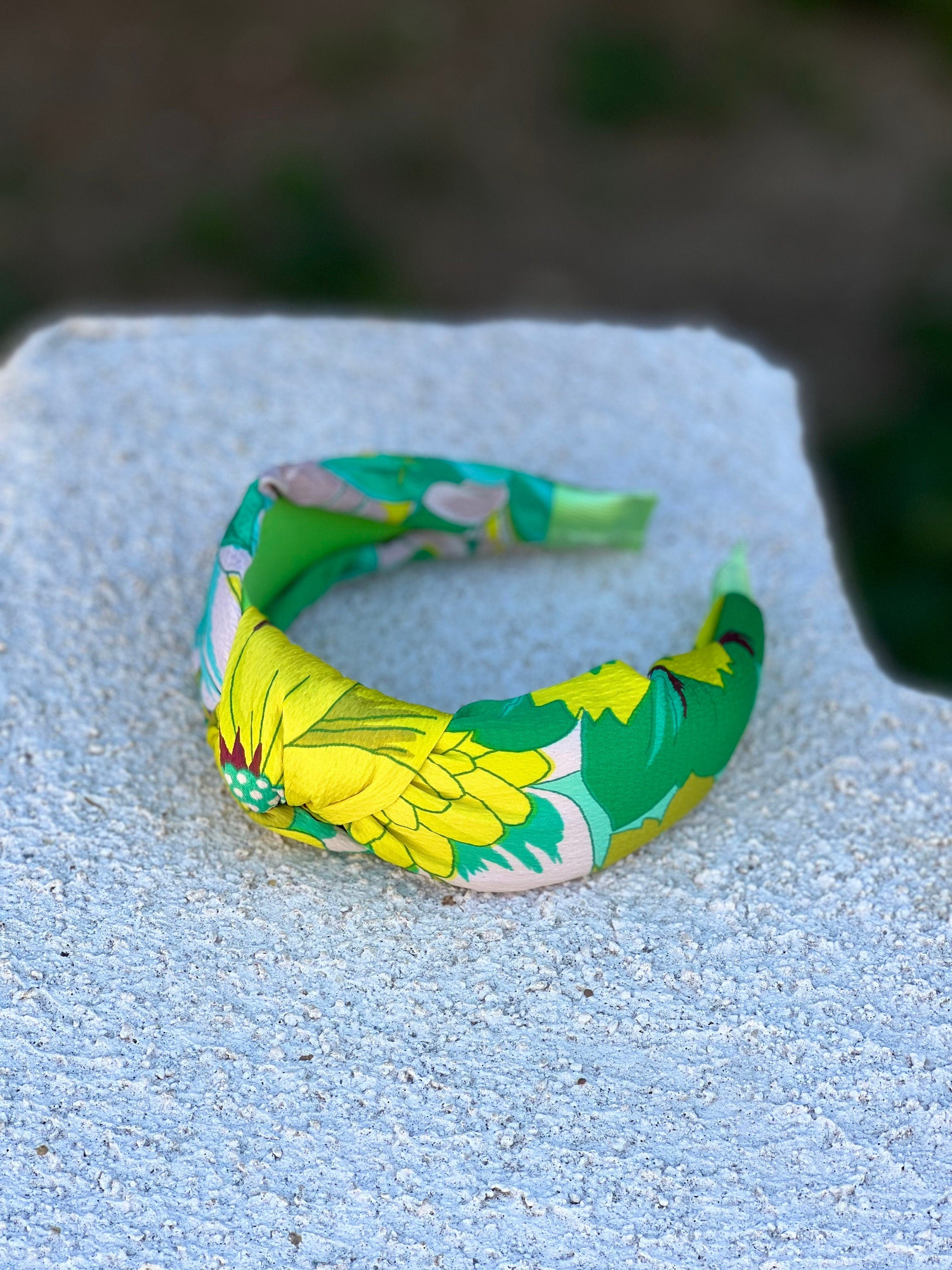 A side profile of a woman wearing the green and yellow flower pattern knotted headband, highlighting its comfortable and secure fit.