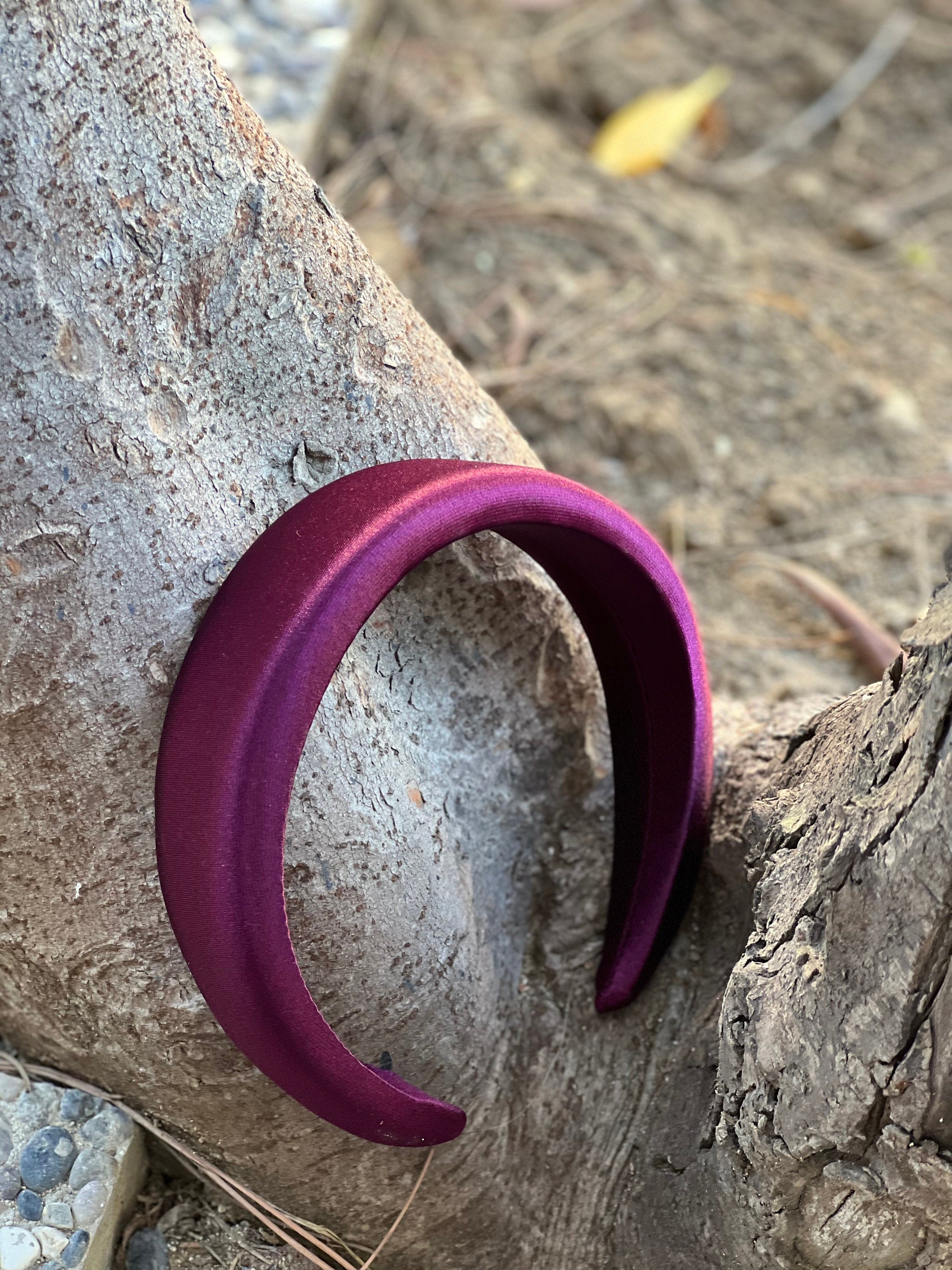 A maroon-colored satin headband for a pop of color in your hair.