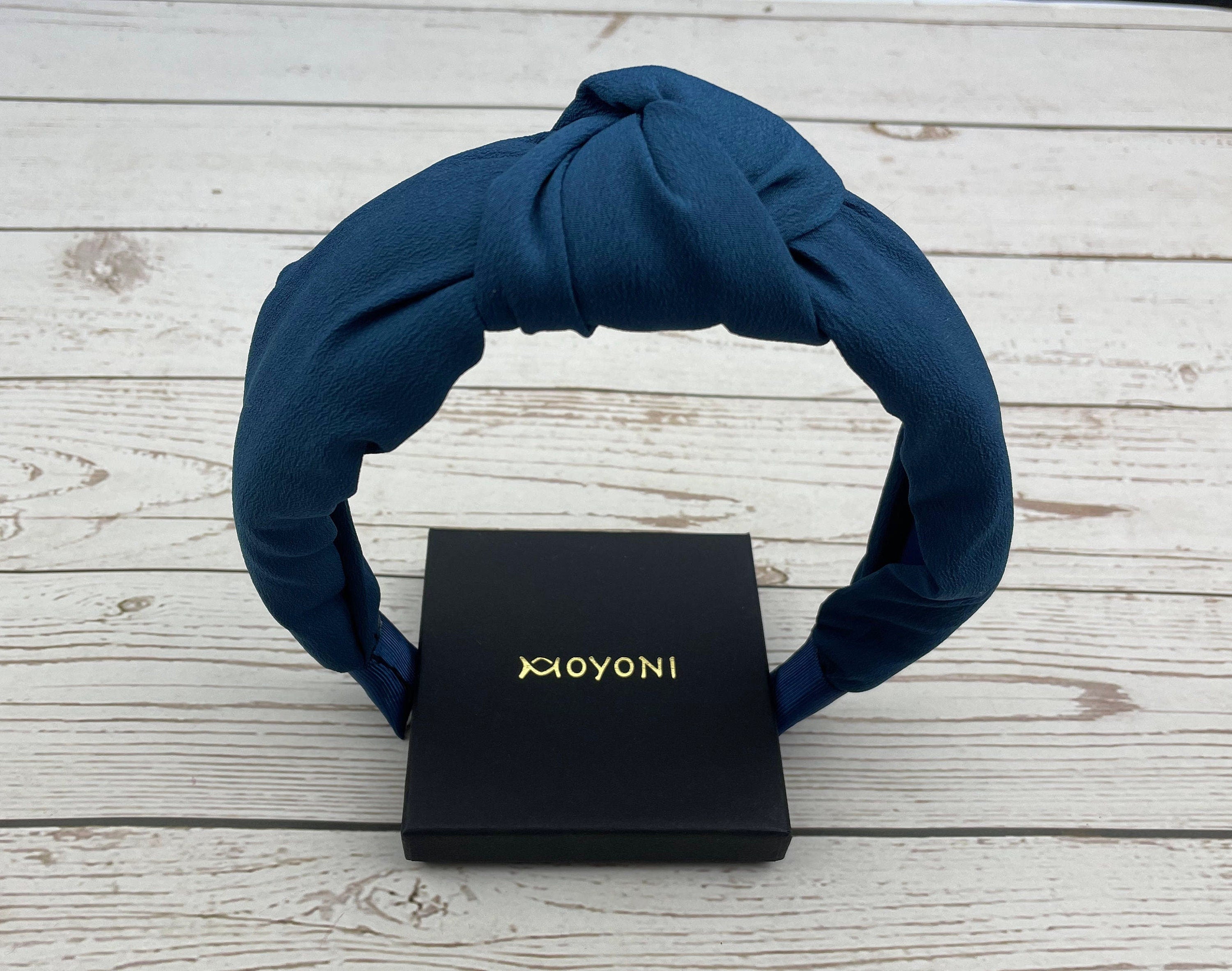 Experience ultimate comfort and style with this dark blue twist knot headband - a must-have accessory for any woman.