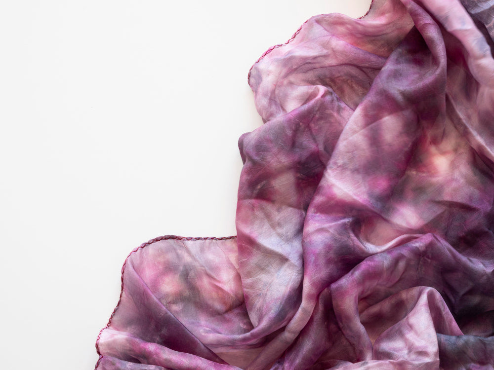 Colorful silk scarves displayed in an elegant arrangement, showcasing various vibrant patterns and textures.