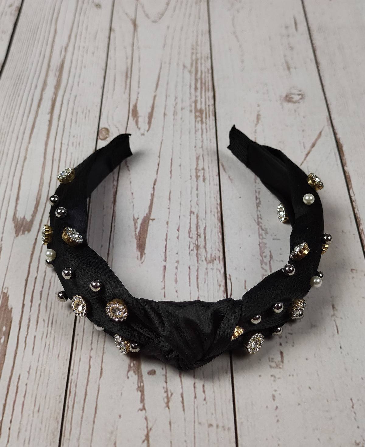 Treat her to a unique and stylish hair accessory with this black satin knotted headband, embellished with precious gems and pearls.