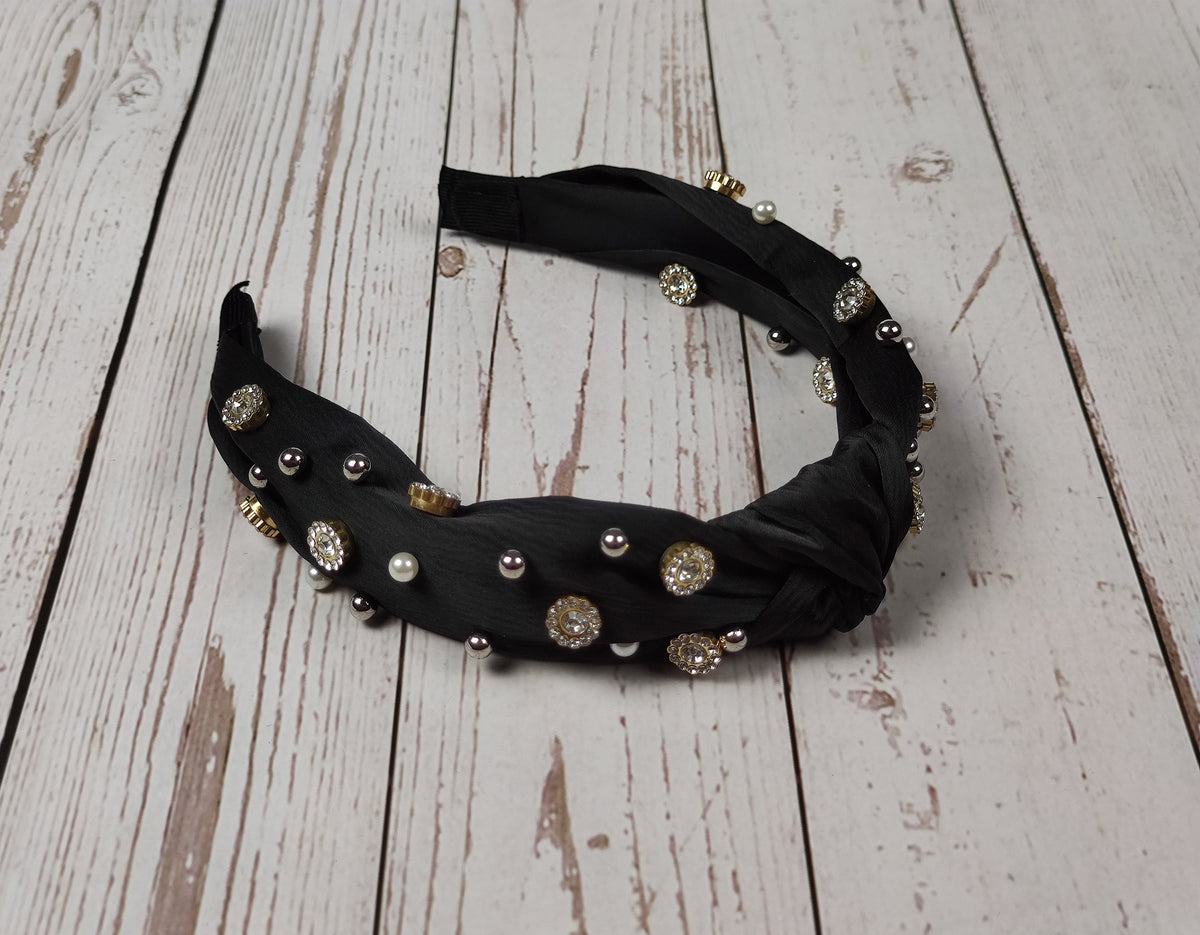 Stand out from the crowd with this special black satin knotted headband, designed with a chic boho touch and sparkling gemstones and pearls.