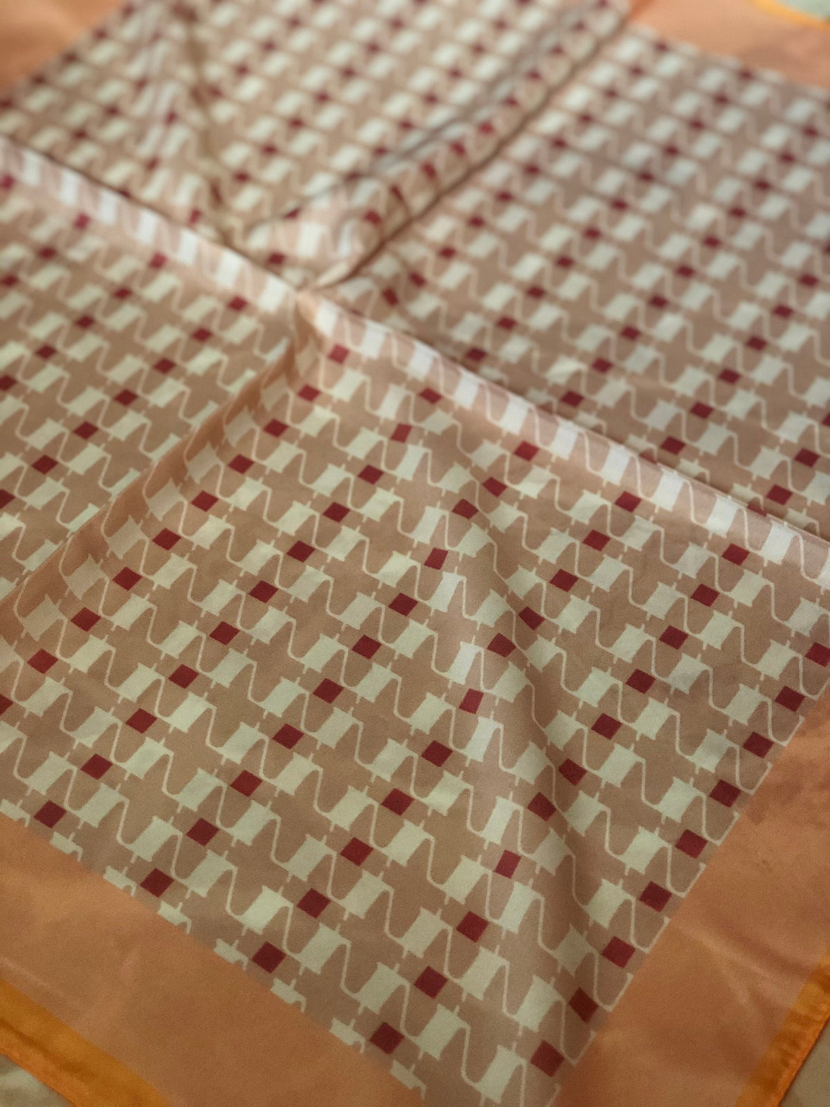 Light and airy silk blend neck scarf with geometric pattern, ideal for spring weather.