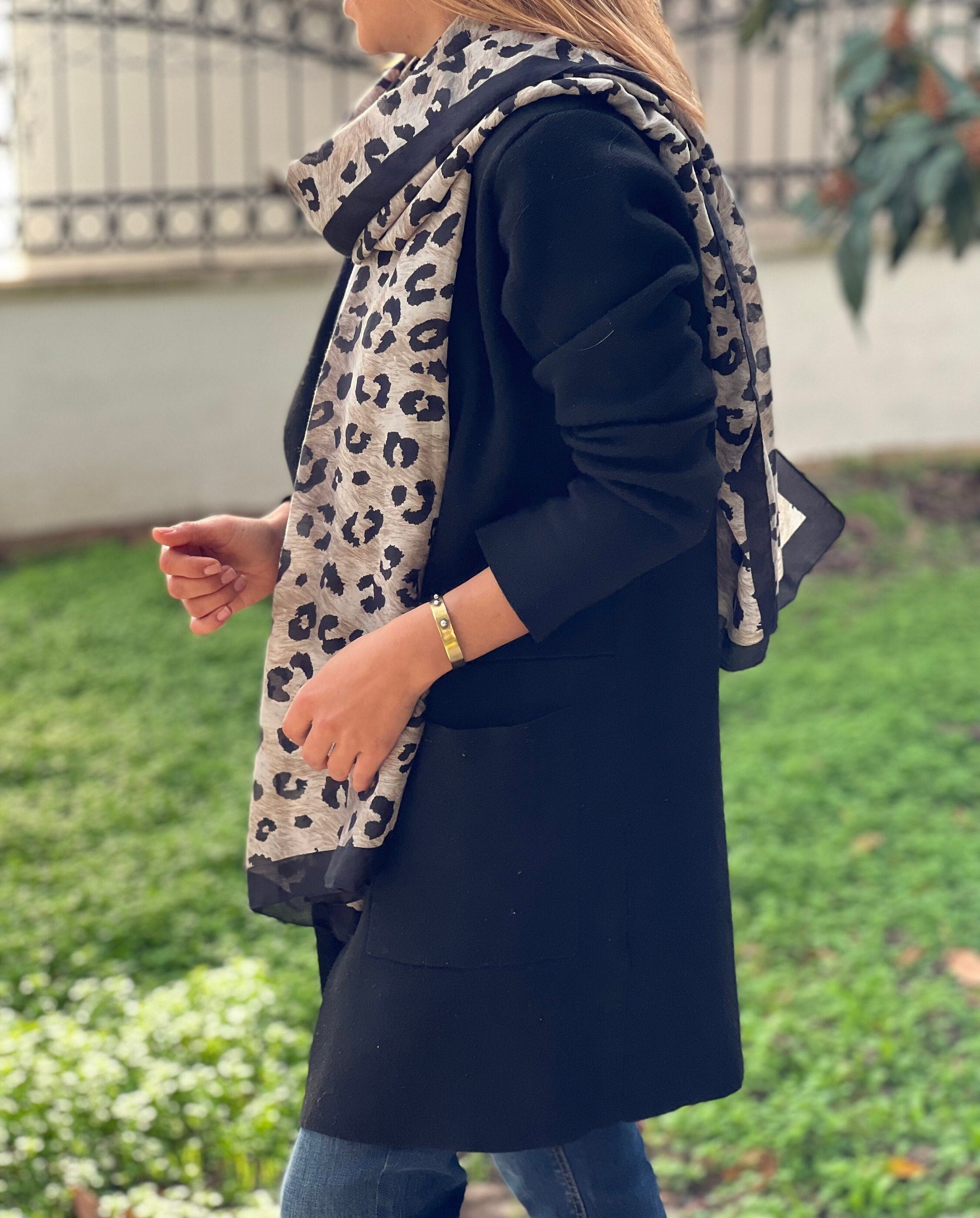 Add a touch of wild style to your outfit with this black and beige leopard printed shawl. Perfect for any season, this animal print scarf is soft and comfortable