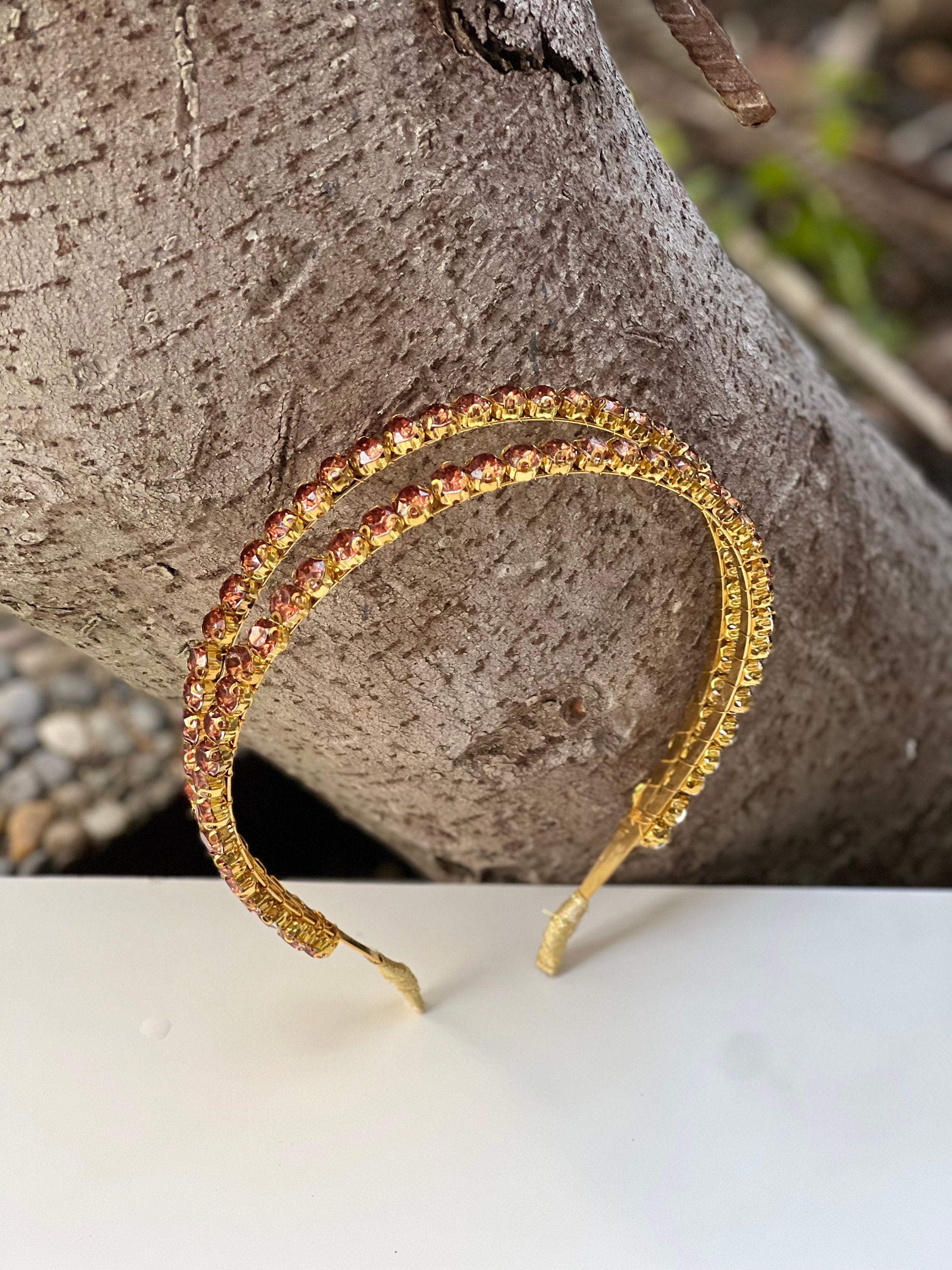 Looking for a chic and stylish wedding accessory? Look no further than this gold and brown crystal headband. With its shiny finish and stunning crystal accents, it&#39;s the perfect addition to any bridal ensemble.