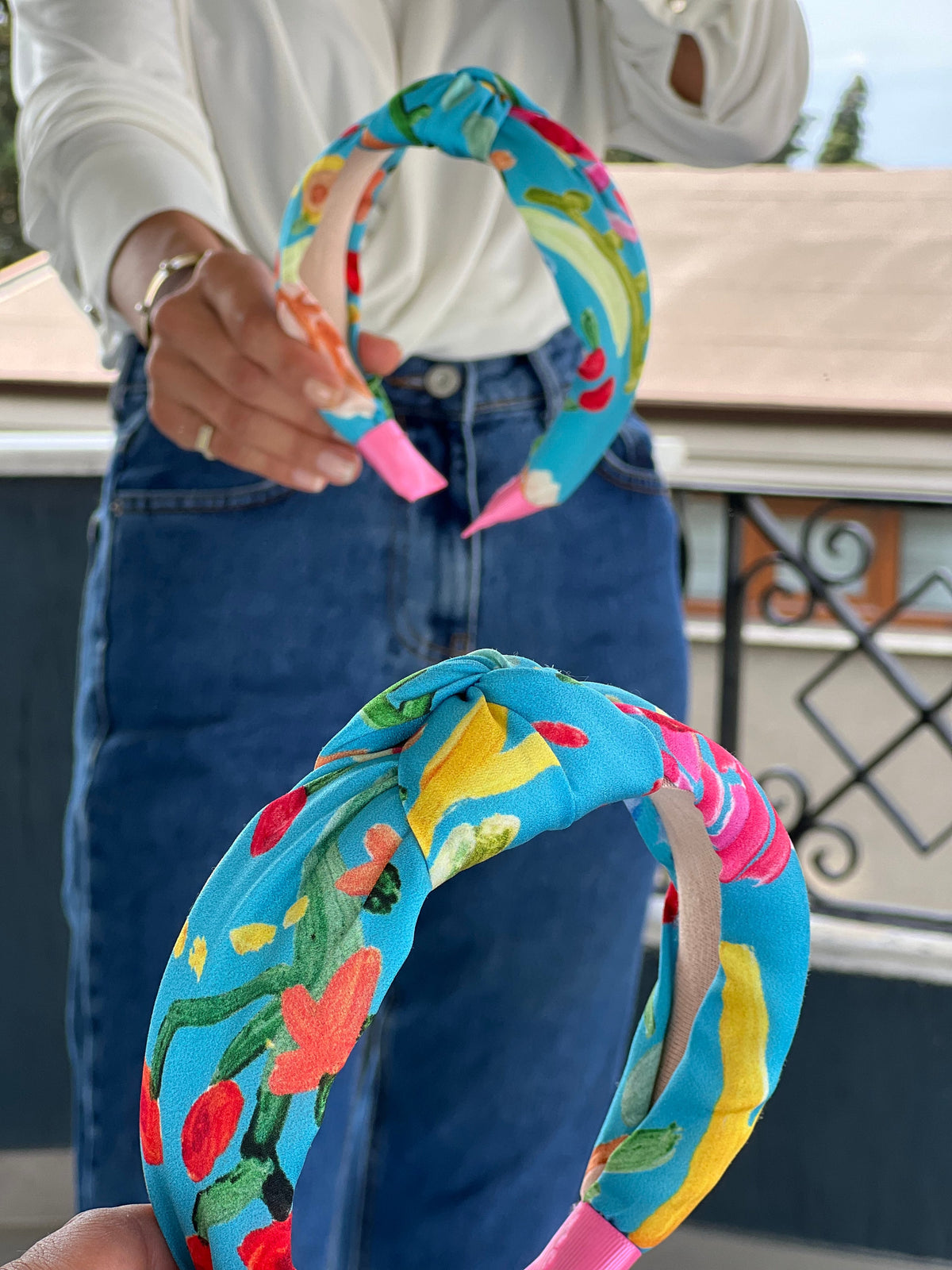 This beautiful headband features a flower pattern in blue, orange, pink, and green colors, adding a touch of elegance to any hairstyle.
