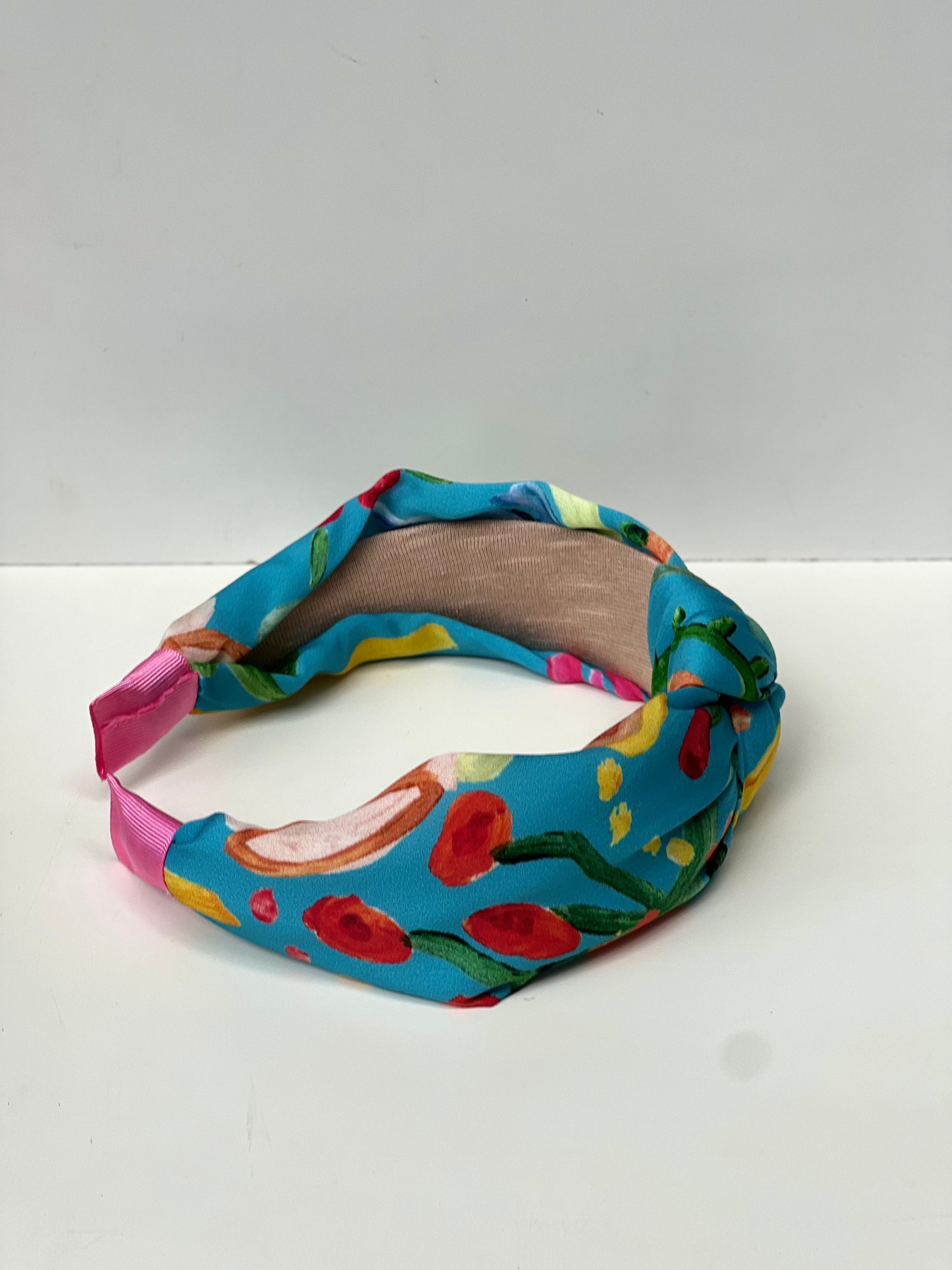 This headband is perfect for those who love to play with colors and patterns. The mix of blue, orange, pink, and green is sure to complement any outfit.