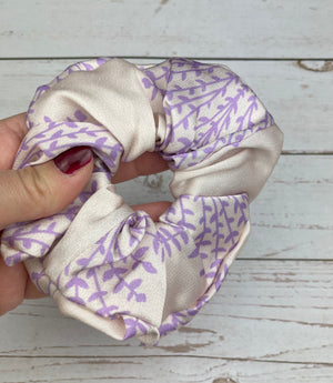 Accessorize your hair with this one-of-a-kind handmade scrunchie, featuring a colorful leaf pattern and a satin bow for added charm.