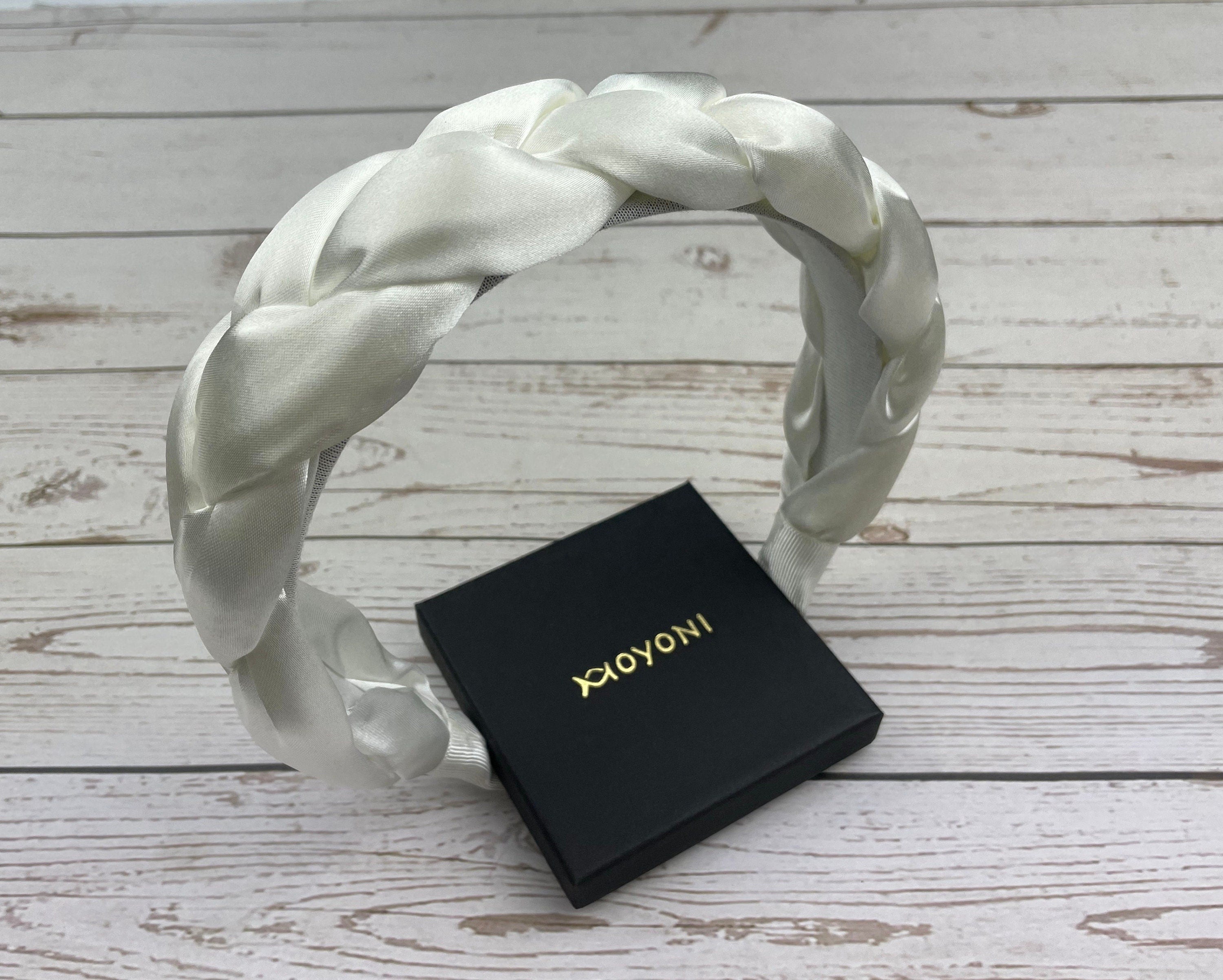 Stay comfortable and fashionable at any celebration with this Snow White Padded Satin Knitted Headband. The plush satin padding and knitted design make it a must-have accessory for stylish women.