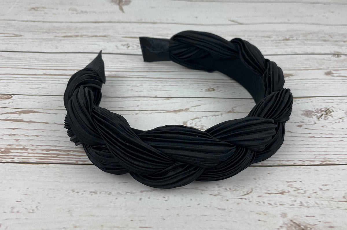 A stylish twisted women's headband in black, featuring a unique design that adds a touch of sophistication to any outfit.