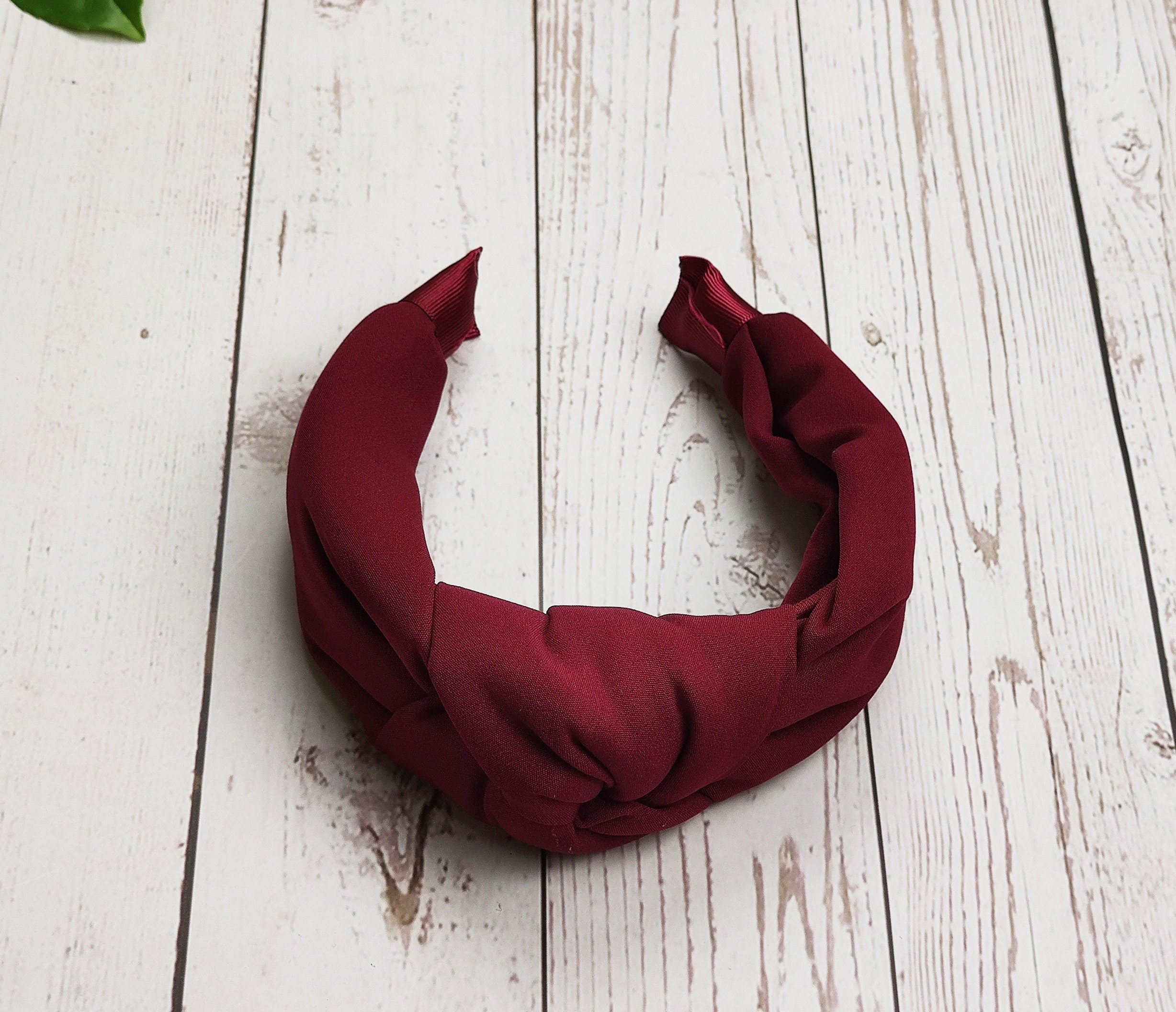Add a touch of sophistication to your hair with our Dark Red Twist Knot Hairband. This designer headband is perfect for making a statement