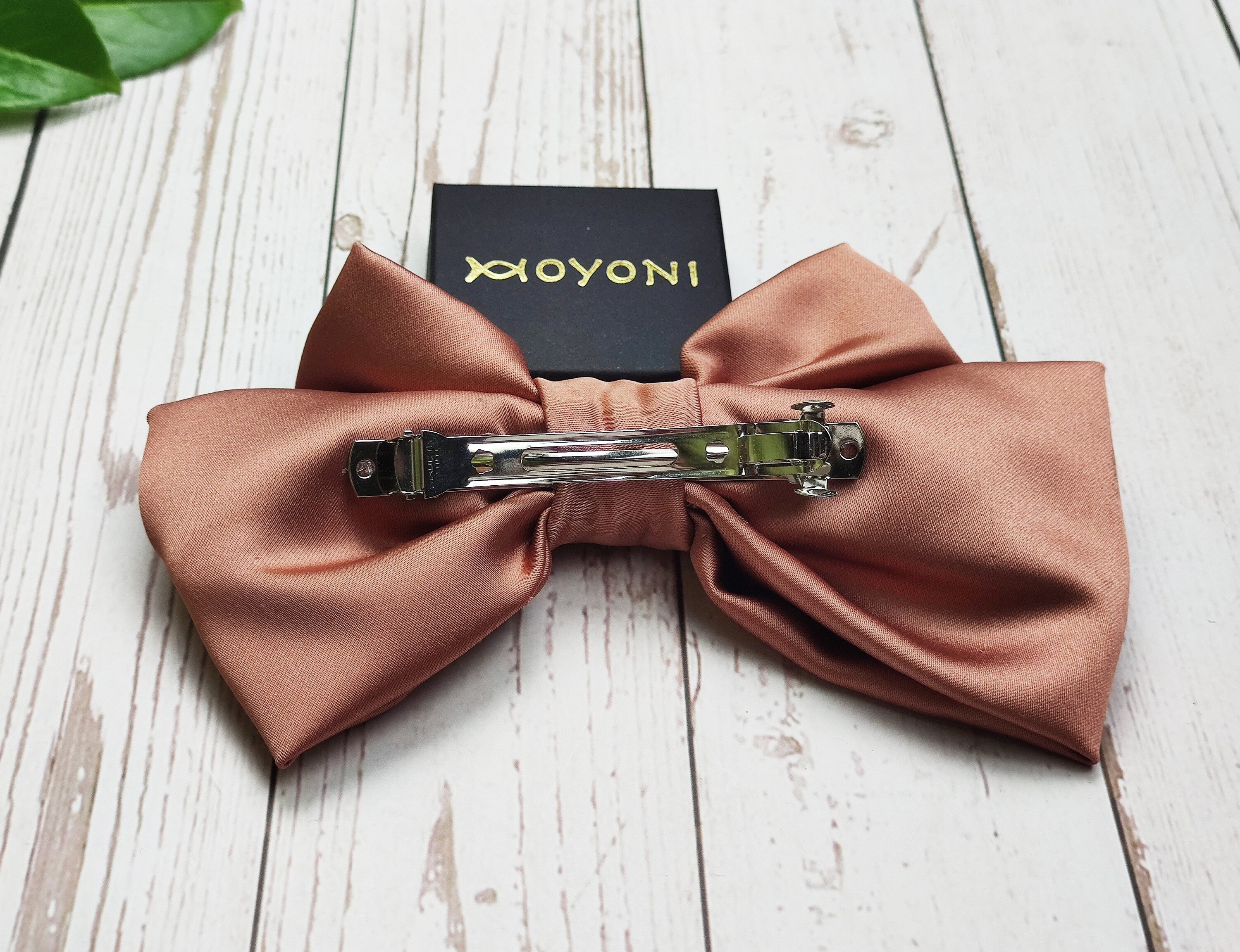 Add a pop of color to your hairstyle with these handmade brick and beige satin hair clips with a bow. The fashionable hair accessory is perfect for keeping your hair in place and adding a touch of style to any outfit.