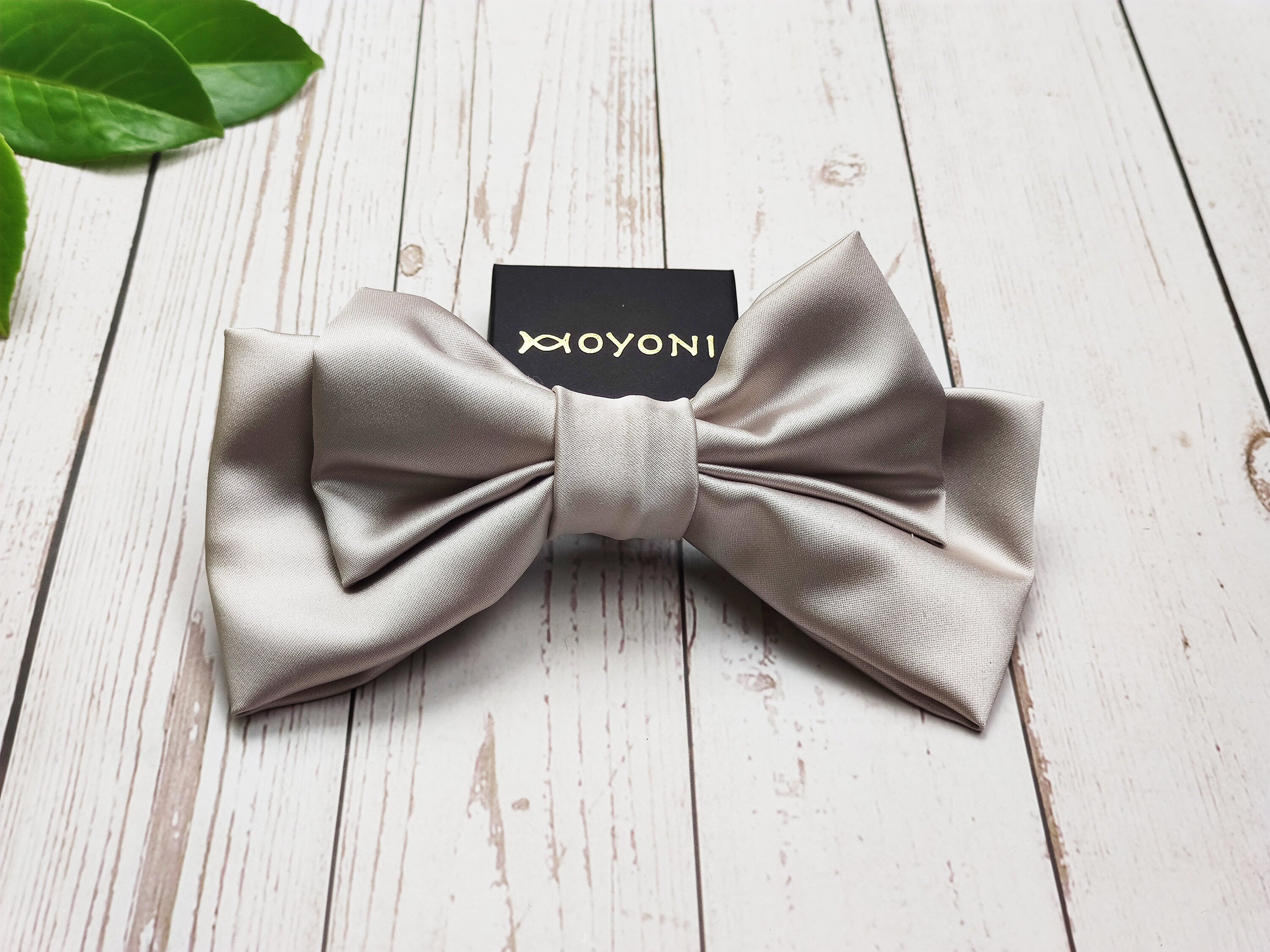 Get ready to turn heads with these handmade brick and beige satin hair clips with a bow. The fashionable hair accessory is perfect for adding a touch of style to any outfit, whether dressed up or dressed down.