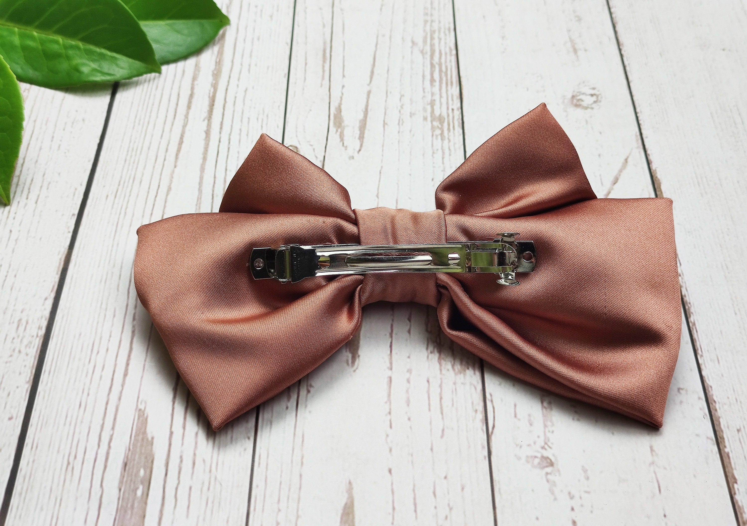 Elevate your everyday hairstyle with these handmade brick and beige satin hair clips with a bow. The fashionable hair accessory is a must-have for any woman who loves to accessorize.