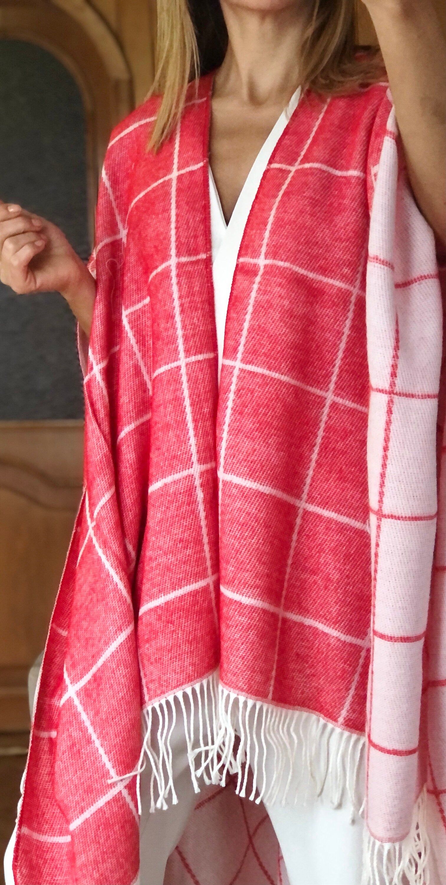 Elevate your winter wardrobe with this large, soft poncho, featuring a warm red and white plaid design.