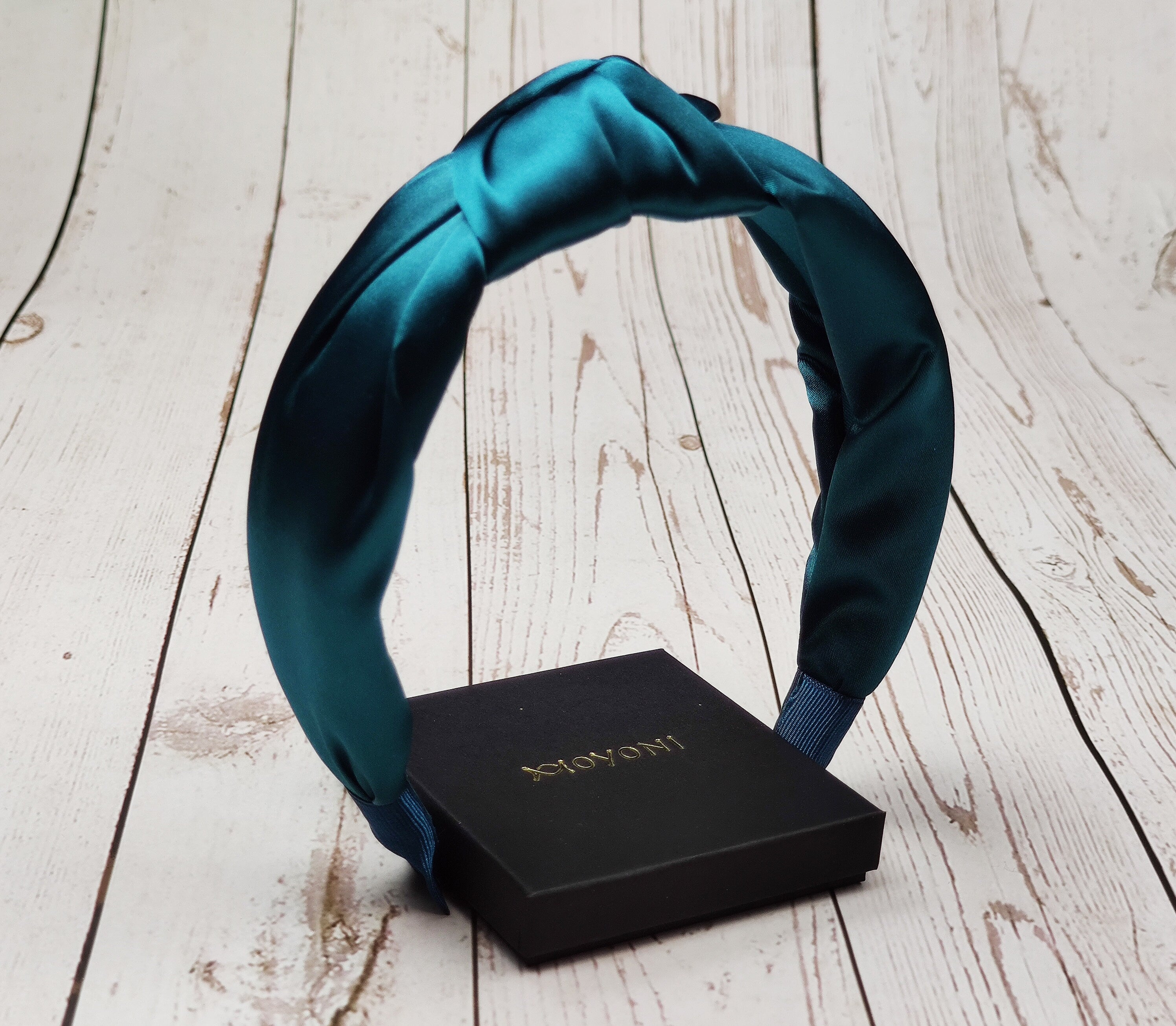 Stay stylish and comfortable with this bright blue-green Patrol Blue Padded Satin Headband. The perfect accessory for women who love to accessorize and add a pop of color to their everyday look.