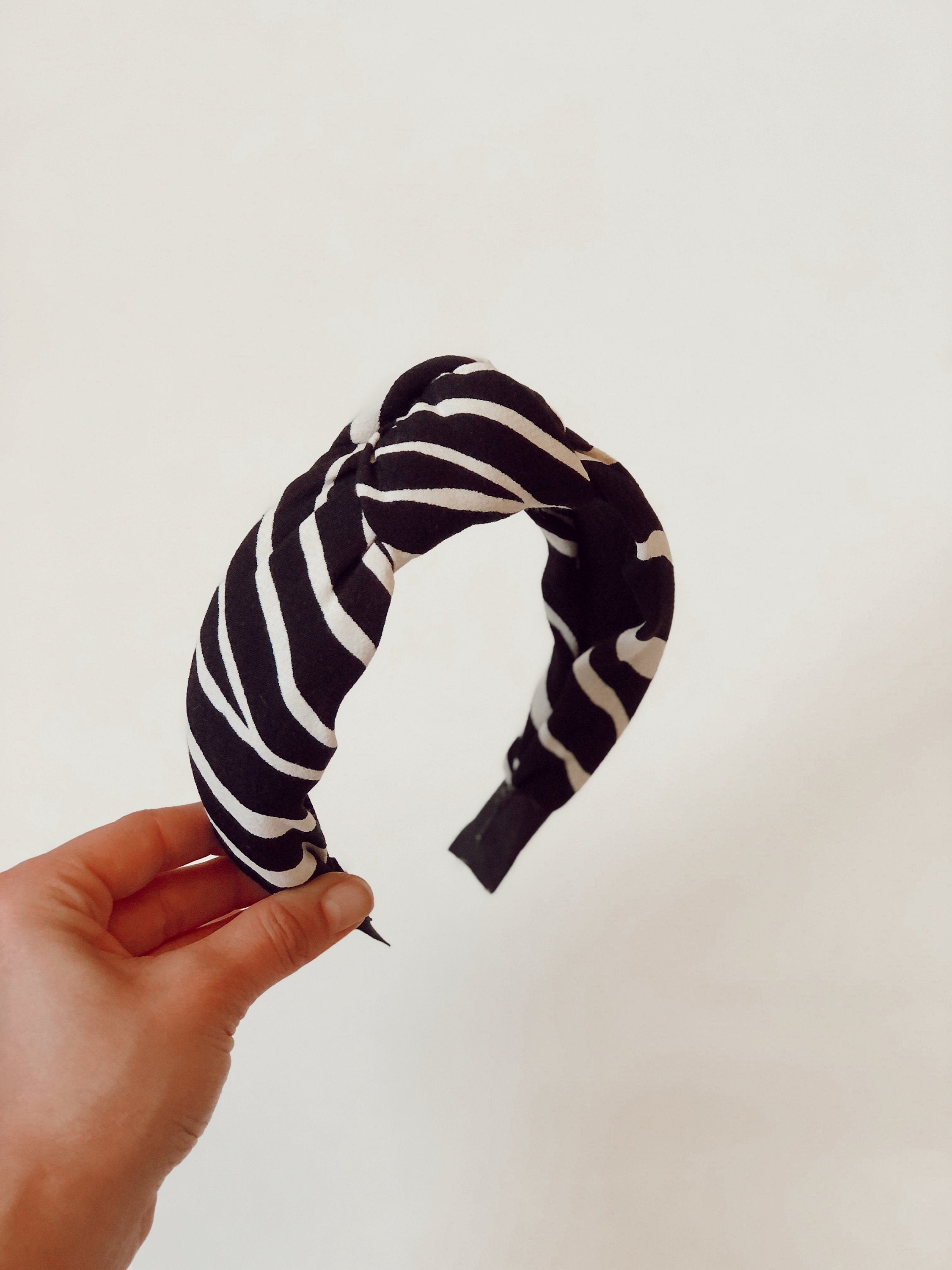 The perfect accessory for any occasion - a versatile knotted headband in a timeless off-white and black colorway.
