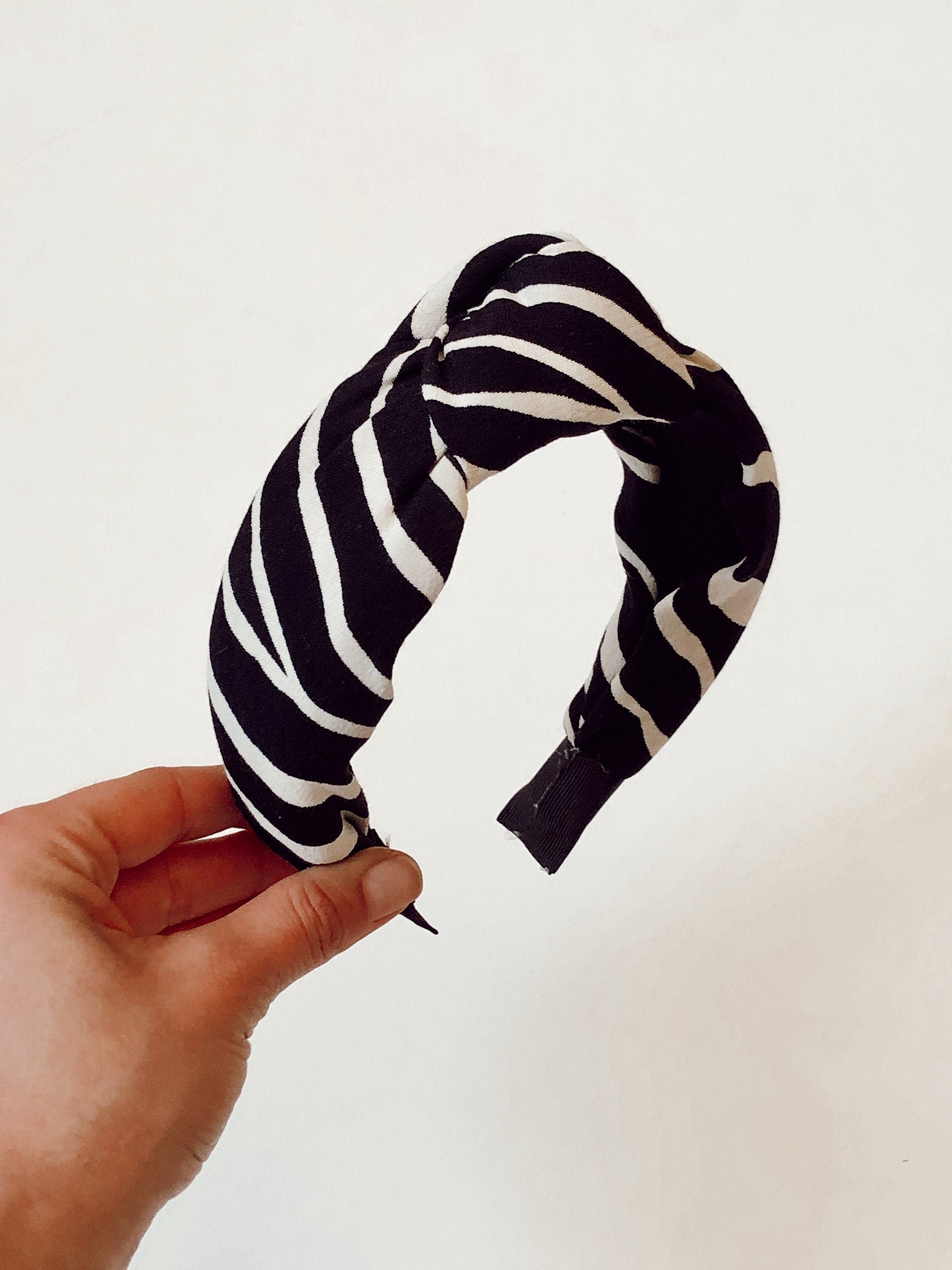 Stay on-trend with this stylish knotted headband in a classic off-white and black color scheme.