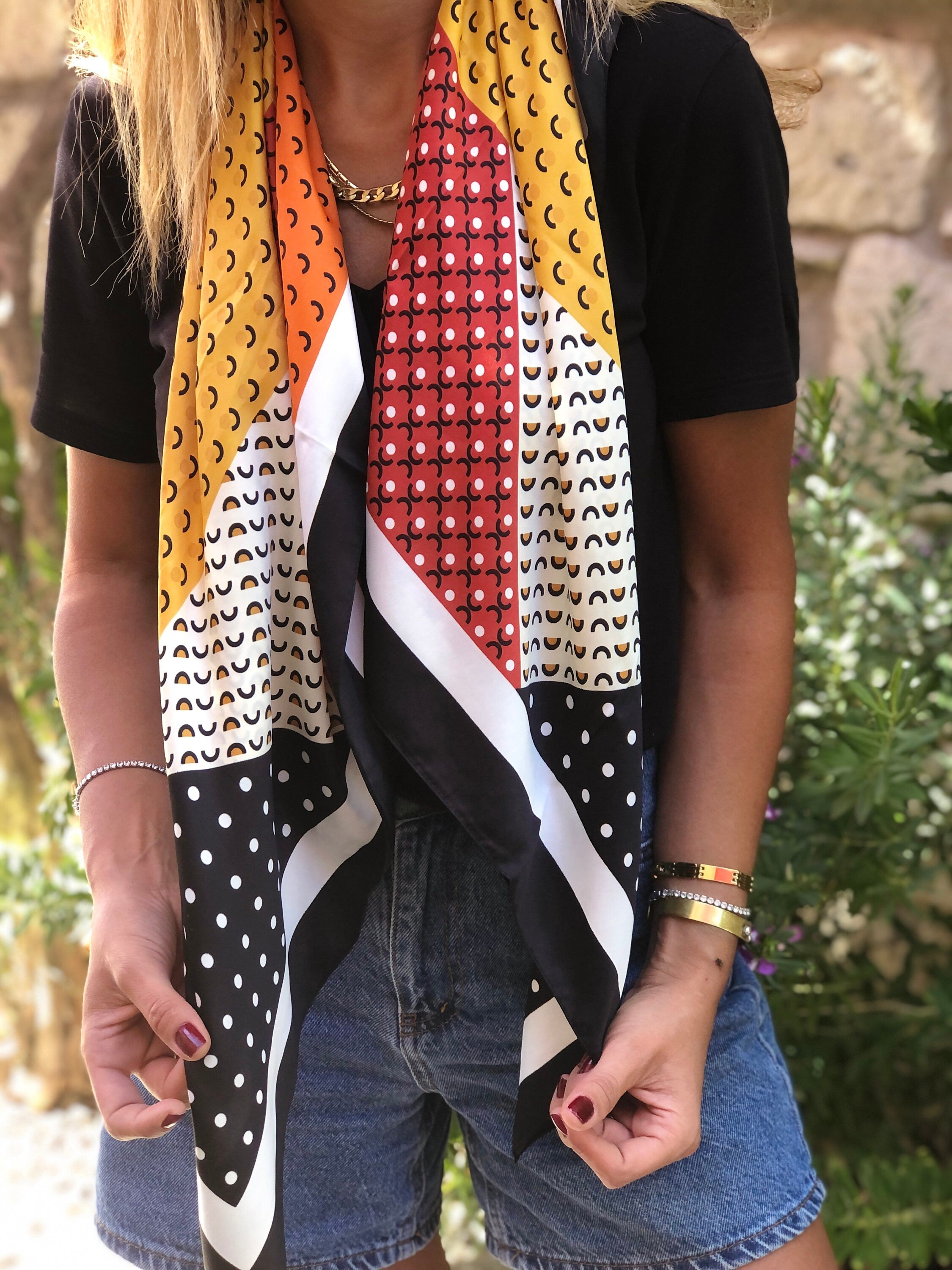 Create a retro look with this stylish square scarf. Made from luxurious satin and adorned with a beautiful spotted pattern, it is the perfect accessory for any fashionable woman.