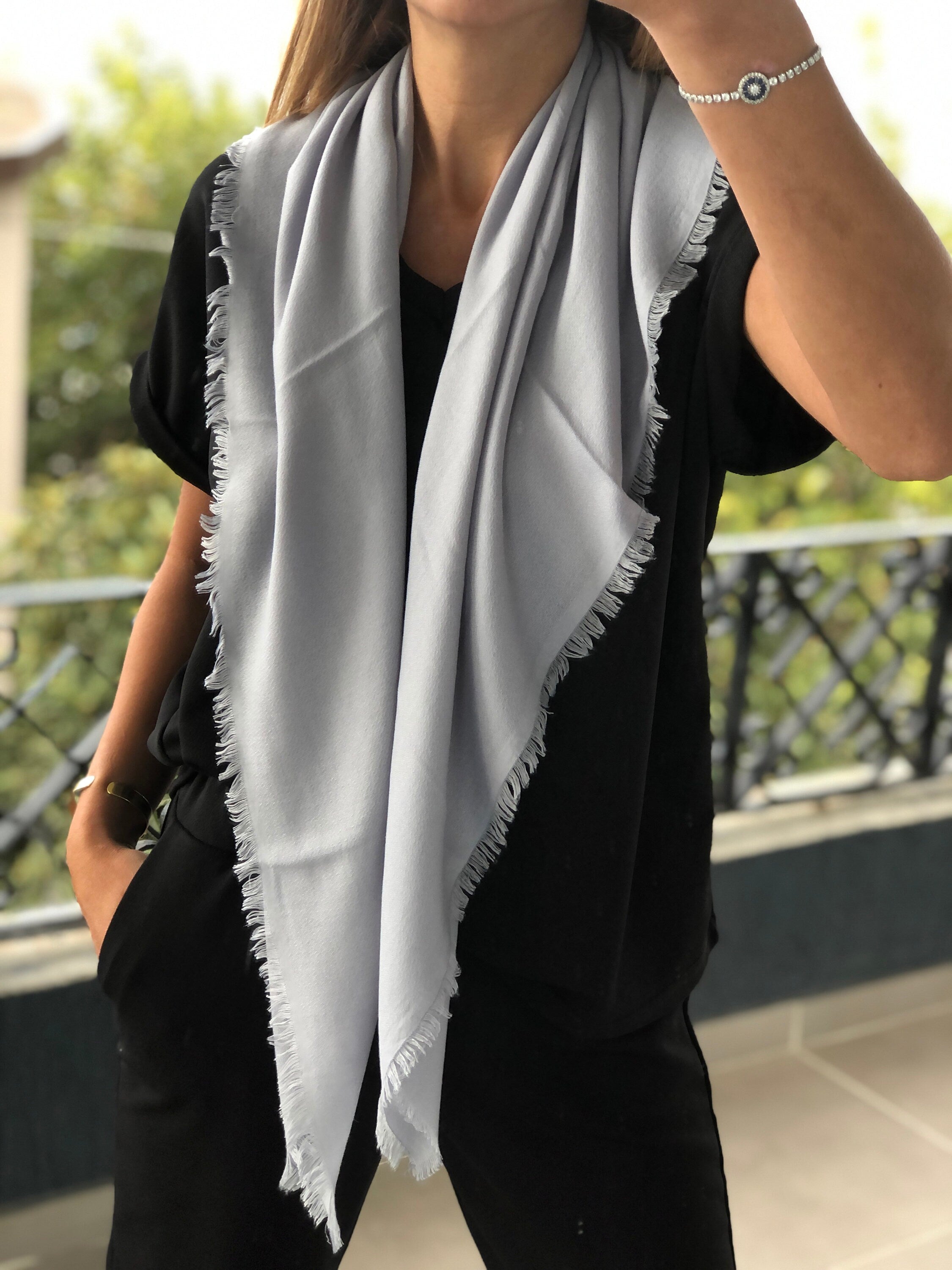Add a touch of sophistication to your outfit with this light gray square scarf.