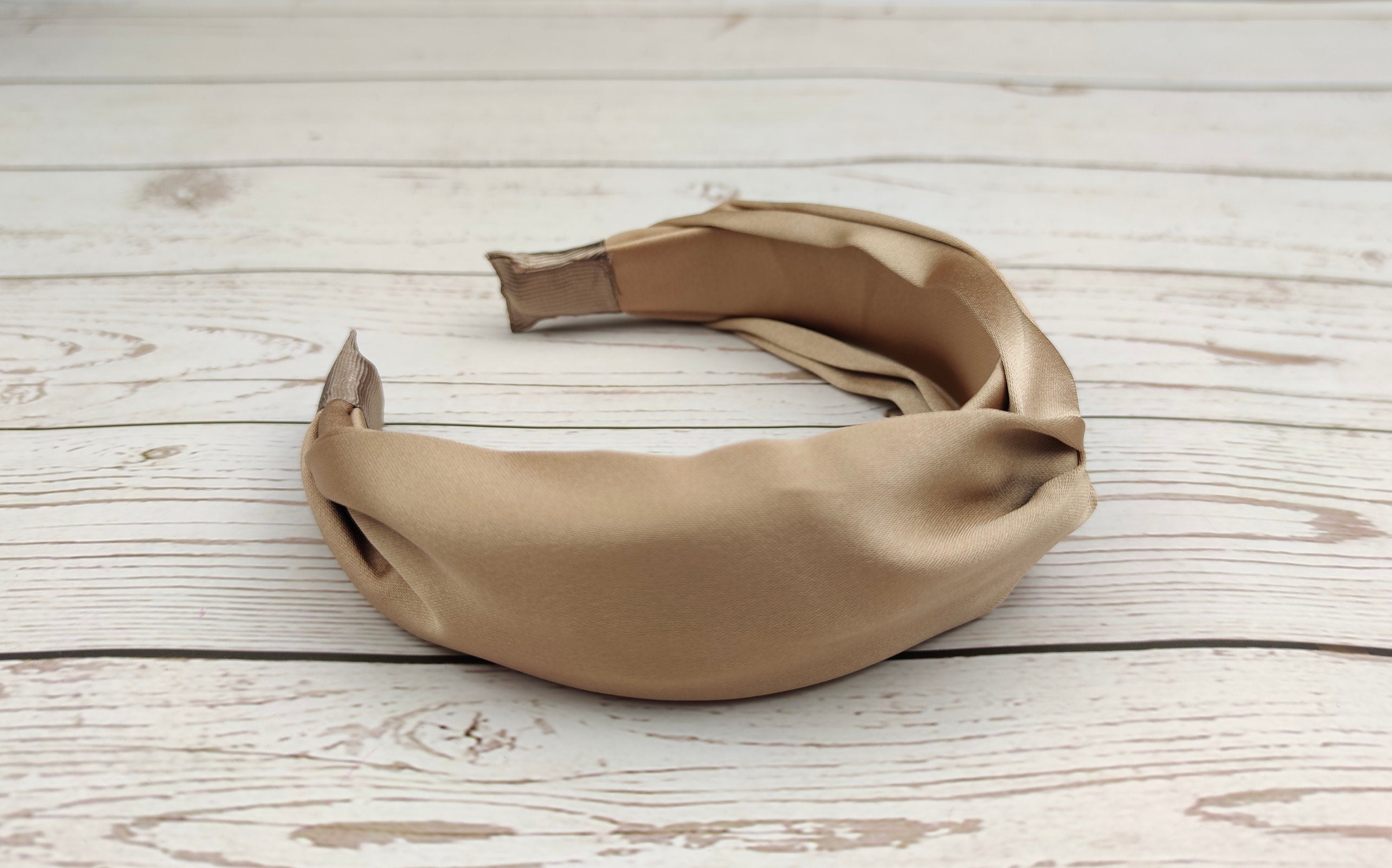 Elevate your summer style with our Cream-Colored Satin Knotted Headband. This headband features a chic knot design and a stunning beige color, perfect for any outfit. The soft and comfortable satin material is perfect for all-day wear.