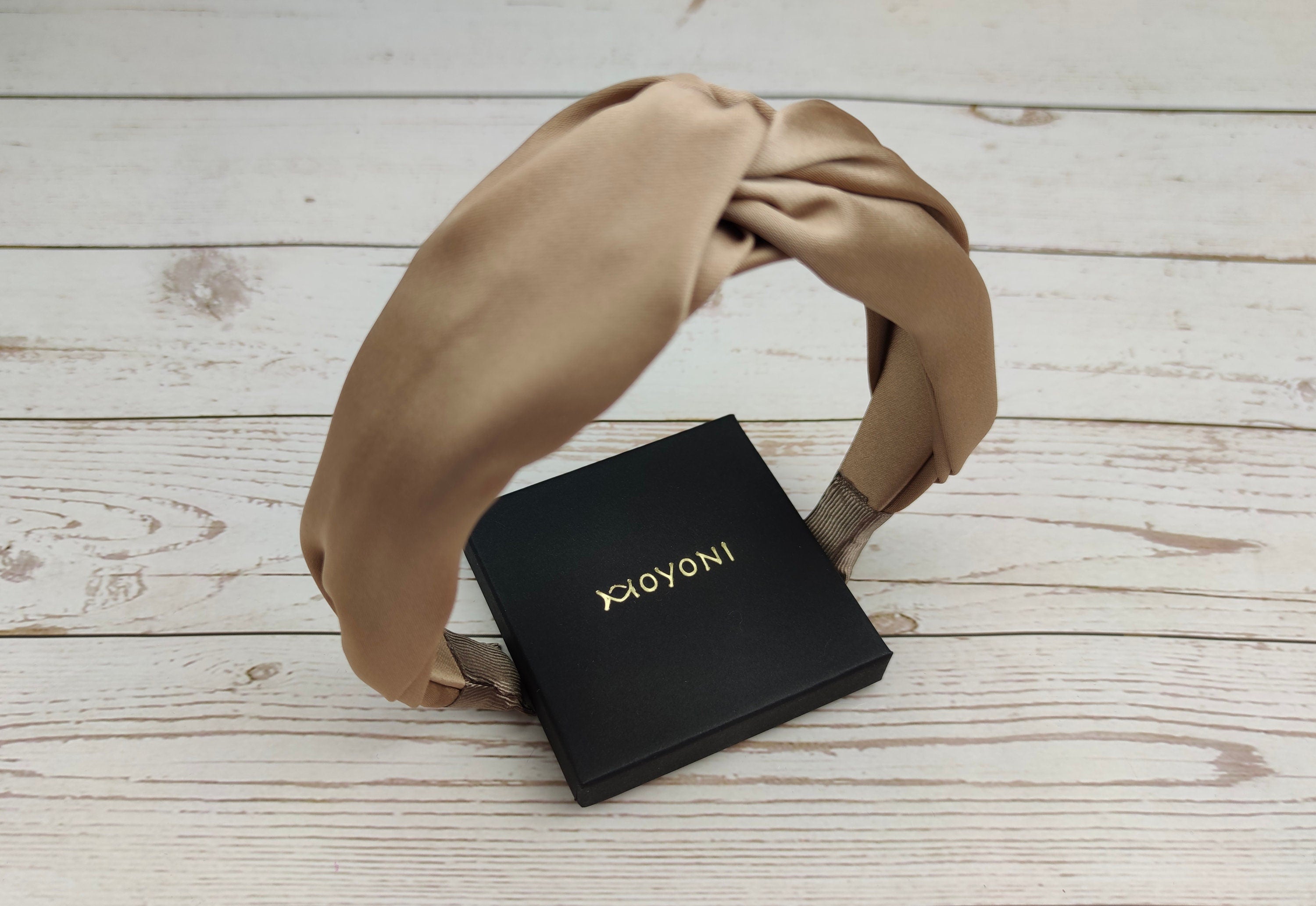 Add a touch of luxury to your summer style with our New Design Fashion Hairband. This headband features a stylish knot design and a beautiful beige color, perfect for any outfit. The soft and comfortable satin material is perfect for all-day wear.