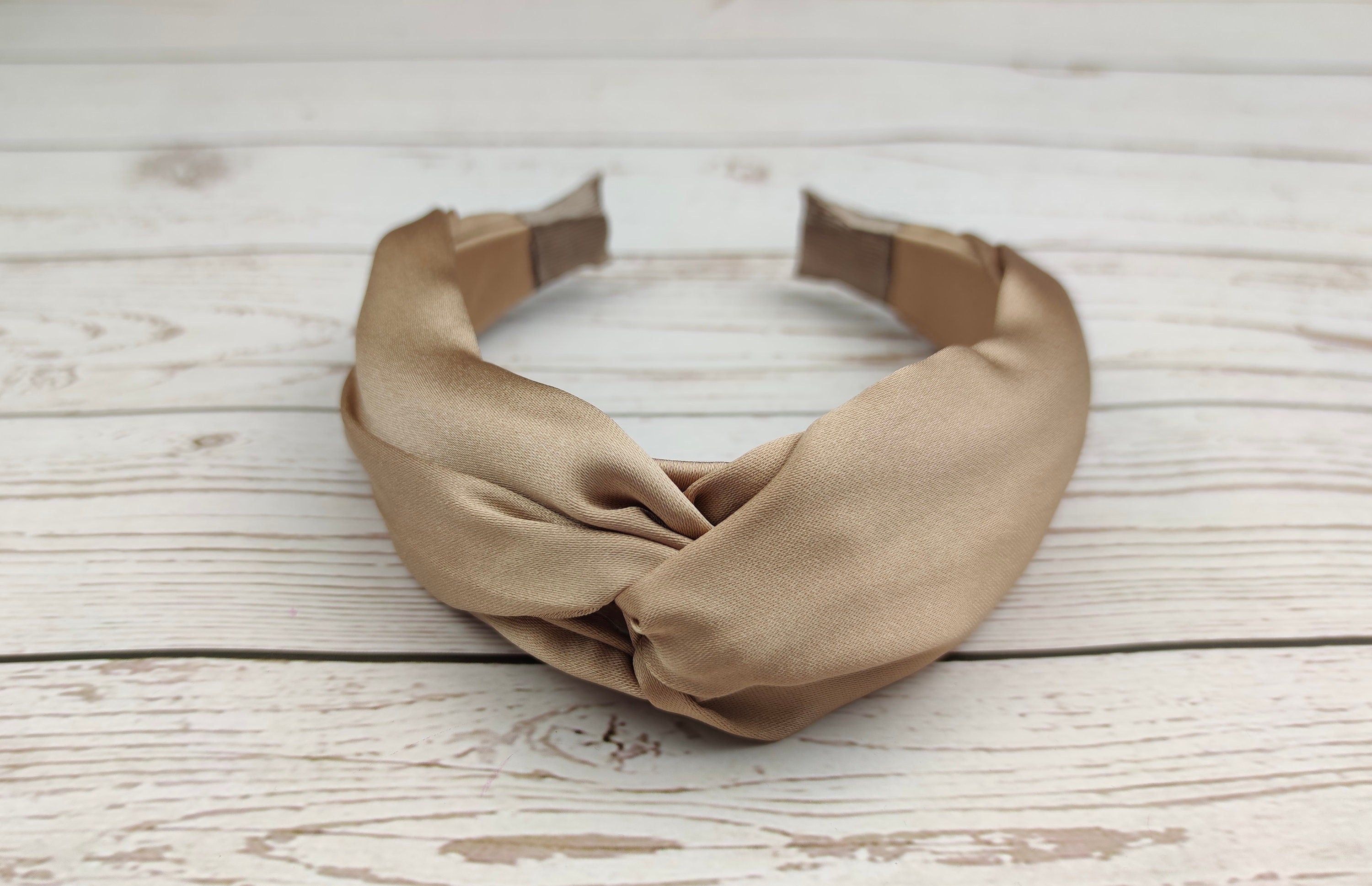 Make a fashion statement with our Beige Satin Knotted Headband. This headband features a chic knot design and a gorgeous cream color, perfect for any summer outfit. The soft and luxurious satin material is comfortable to wear all day long.