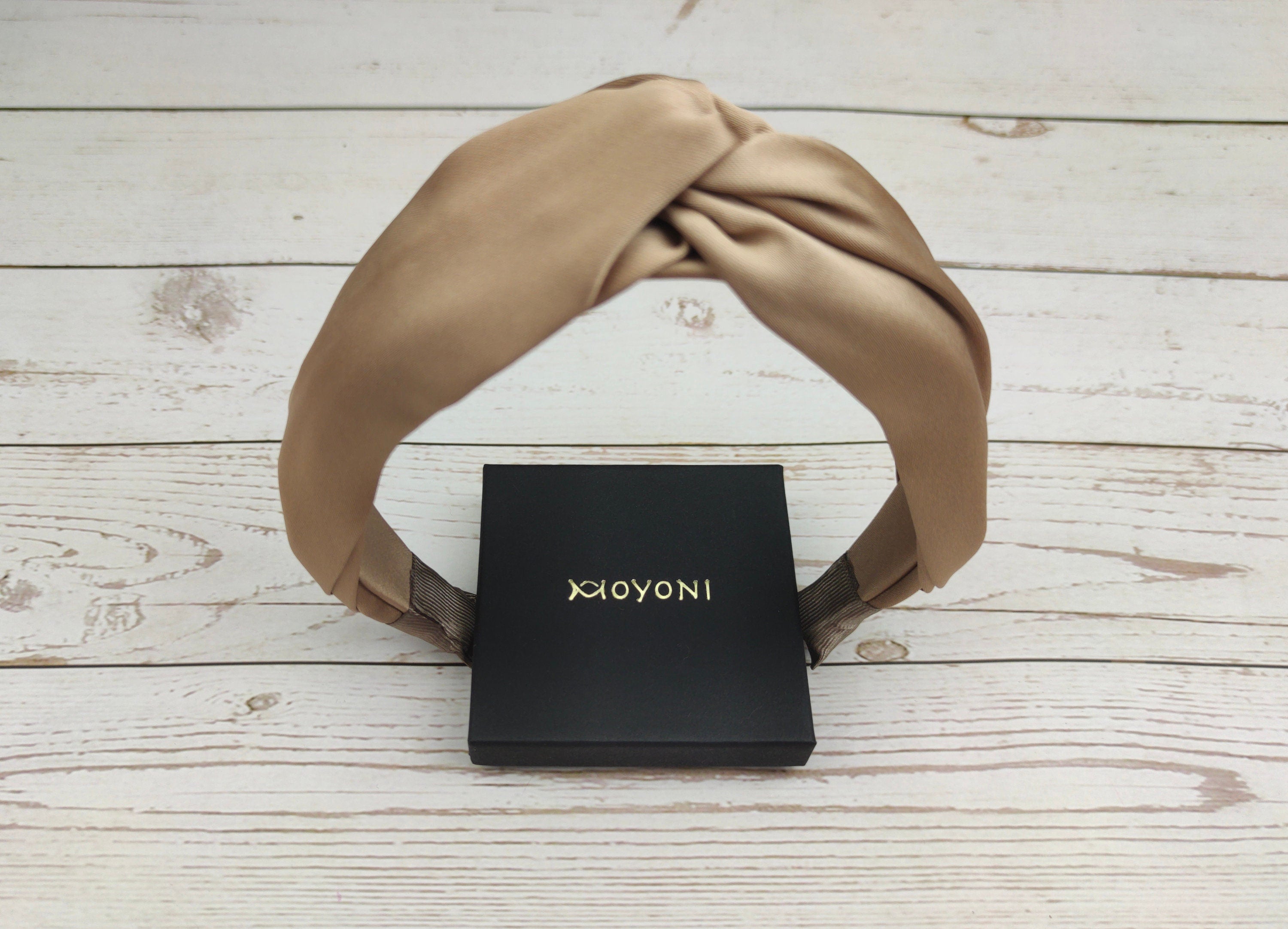 Stay cool and stylish this summer with our Beige Satin Headband. This headband features a knotted design and a gorgeous cream color, perfect for all your summer activities. The soft and luxurious satin material is comfortable to wear all day long.