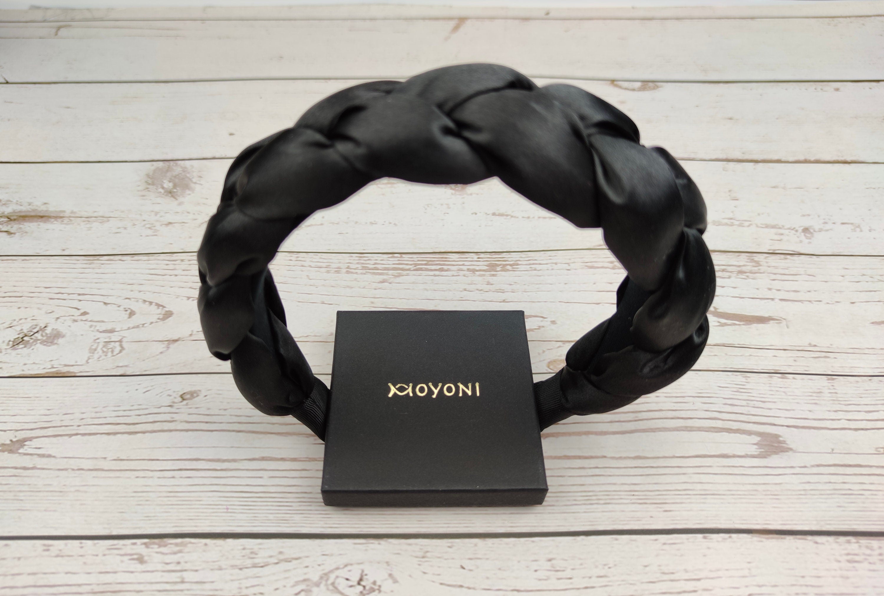 Get the perfect finishing touch for your little girl&#39;s outfit with this black headband, featuring a comfortable padded design.