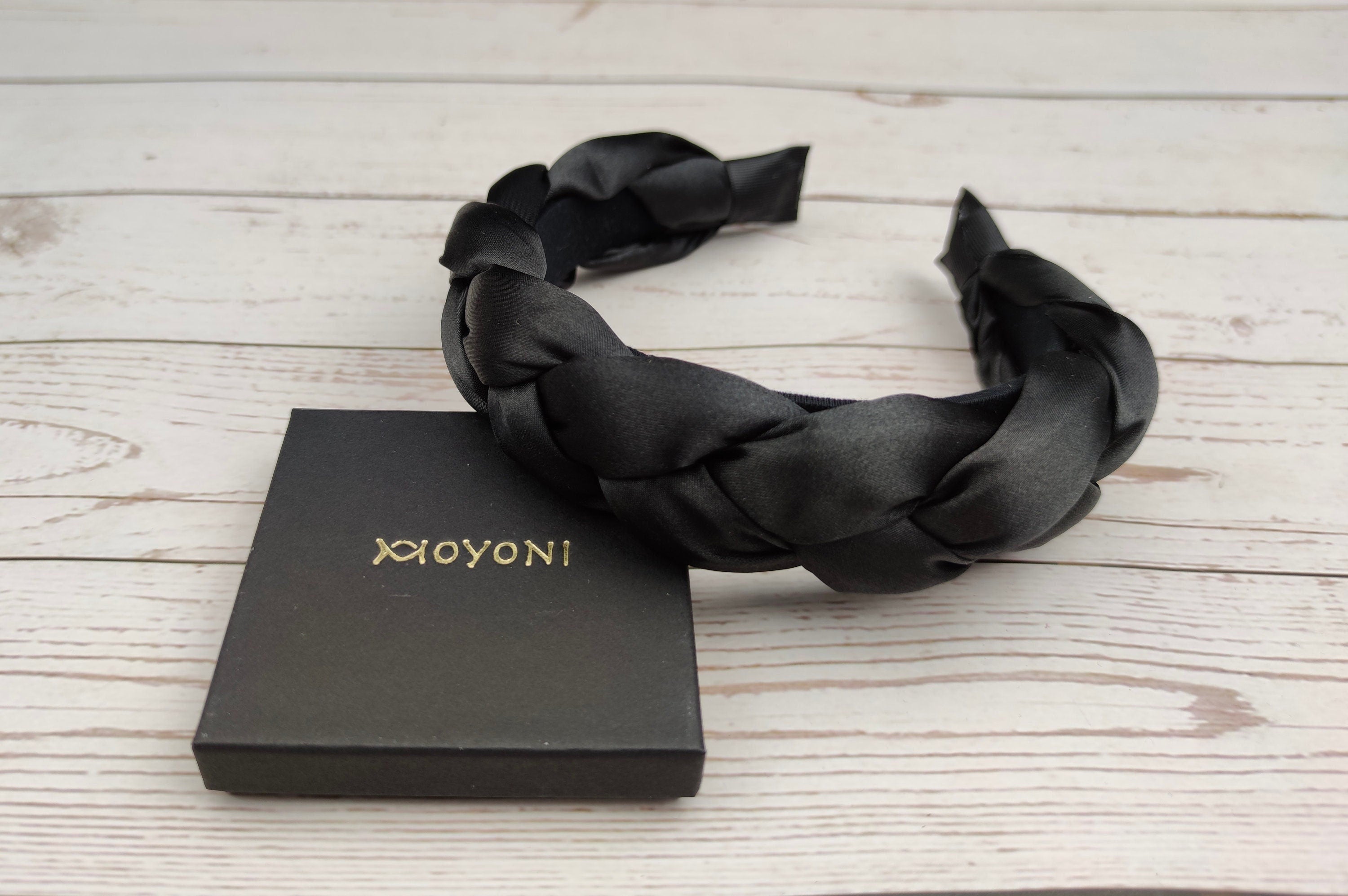 Make a statement with this black padded satin headband, perfect for adding a touch of luxury to any outfit.