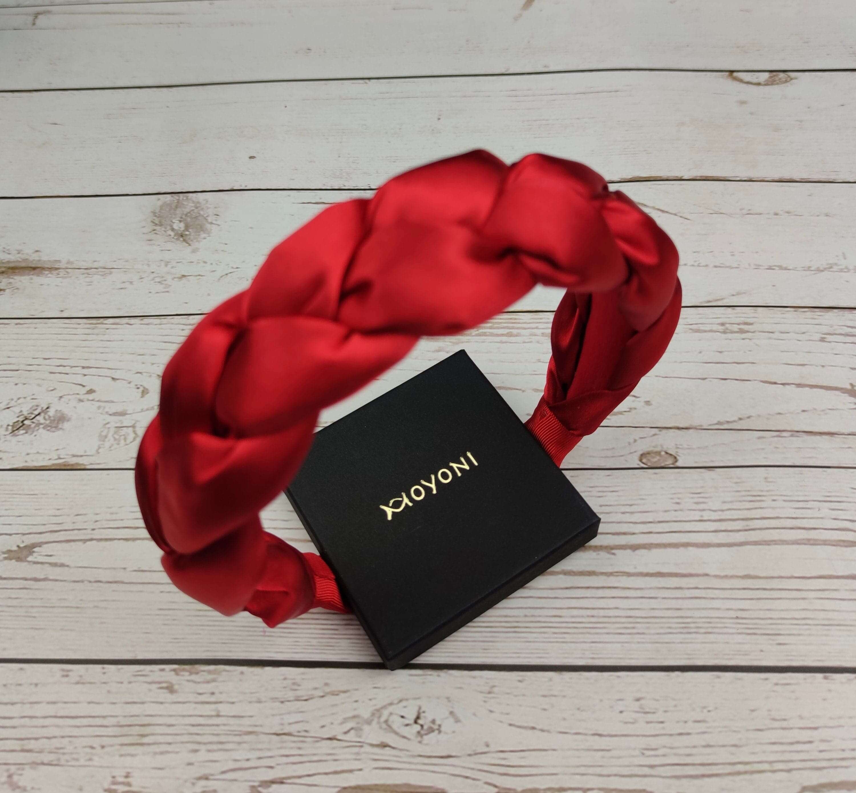 The perfect gift for the fashion-forward woman: a stylish red satin headband with braided detail.