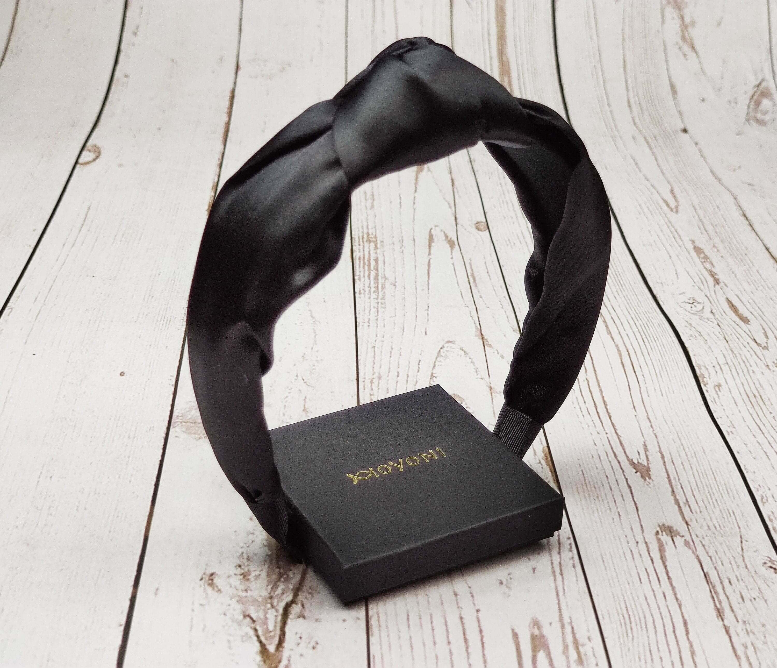 The perfect accessory for any hairstyle: a stylish black satin knotted headband.