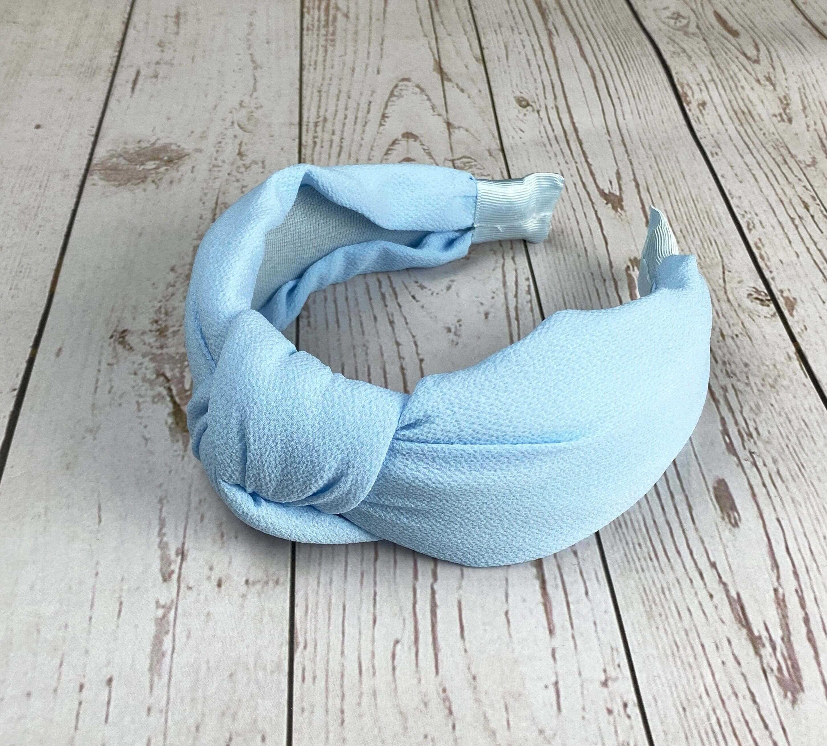 Add a pop of color to your outfit with this baby blue twist knot headband, a fashionable and comfortable accessory for women.