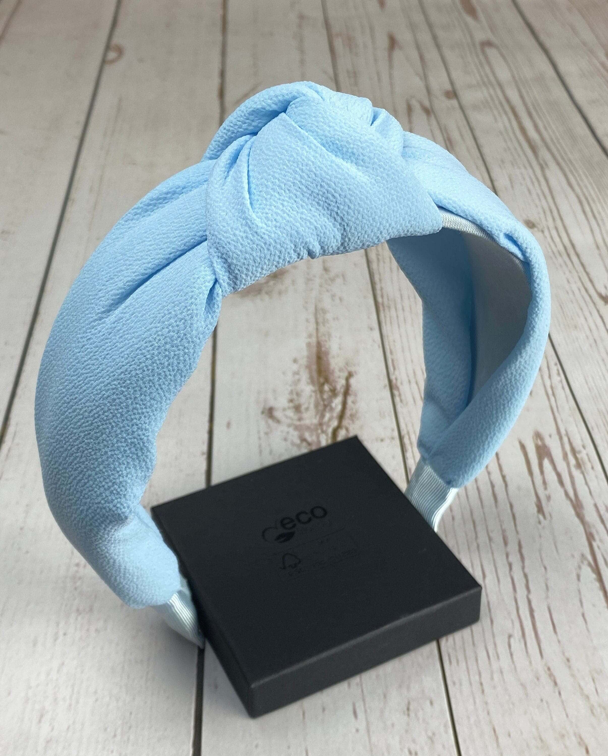 Experience ultimate comfort and style with this light blue, viscose crepe padded headband, designed with a classic knot twist.