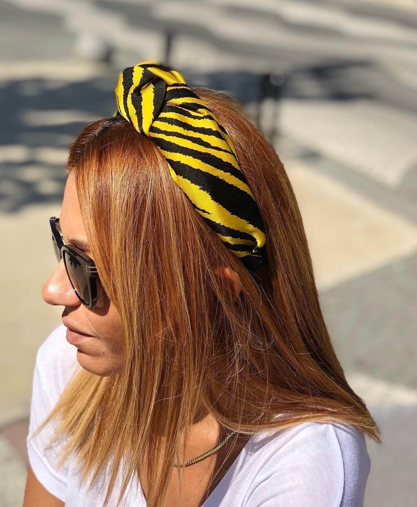 Elevate your accessory collection with this fashionable yellow and black zebra pattern knotted headband, crafted from soft material for ultimate comfort.