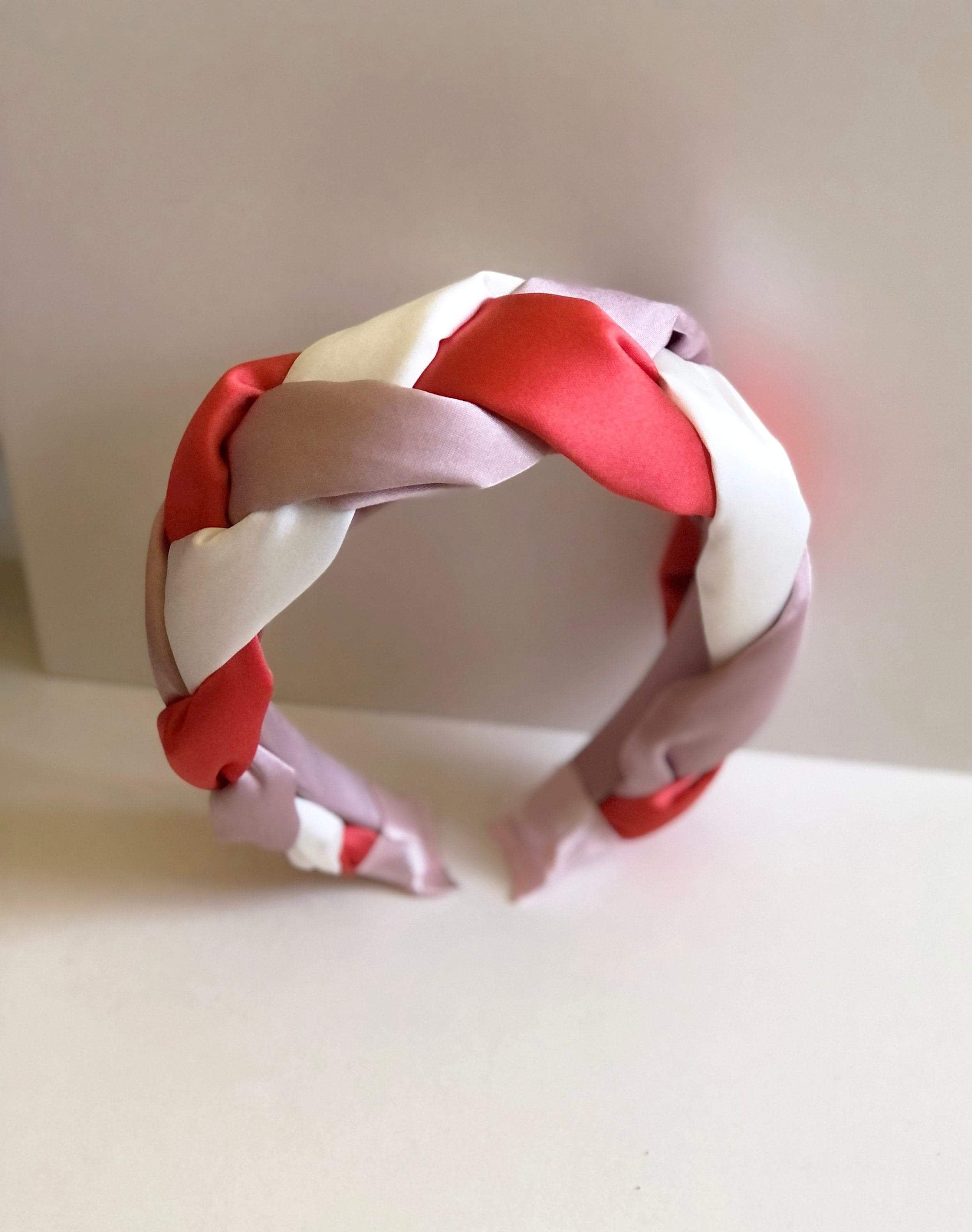 Elevate your look with this stylish padded satin headband, crafted in a unique lilac, white, and light red color, and featuring a twisted design for added flair.
