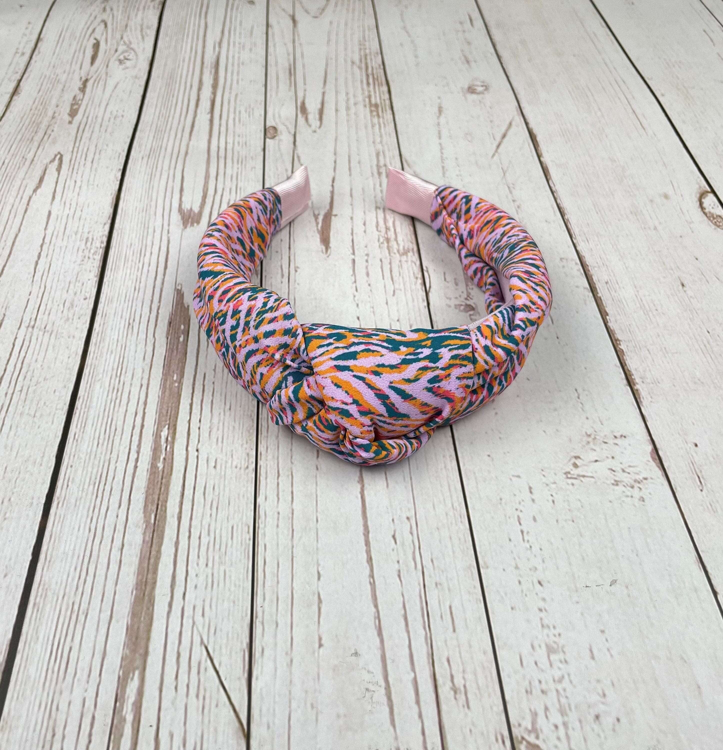 Stay on-trend with this Pink Green Striped Headband, featuring a colorful leopard pattern