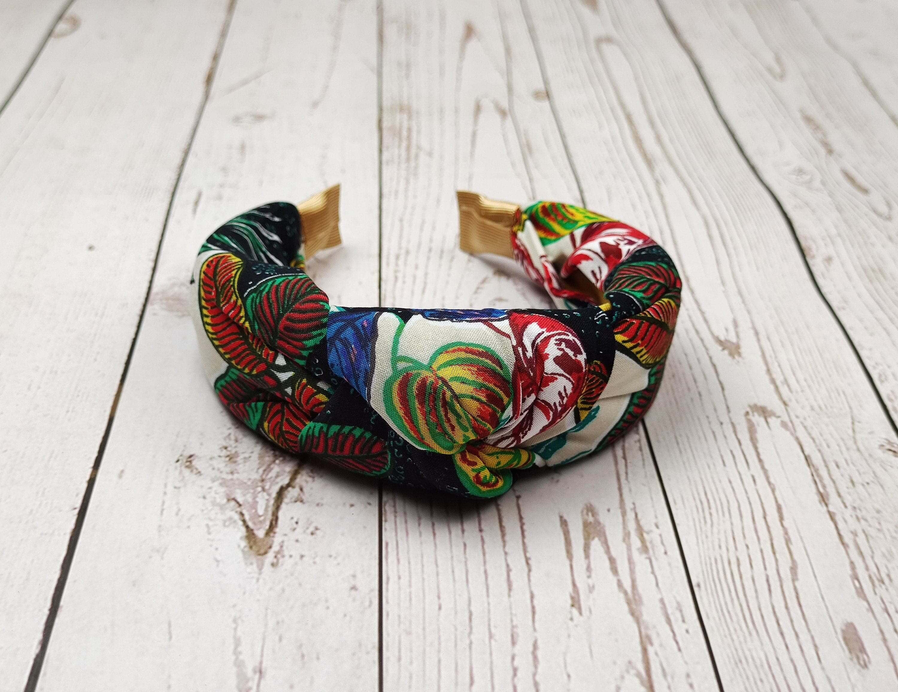 Elevate your hair game with this trendy dark blue, yellow, green, and red knotted headband.